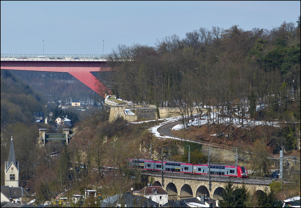 Die RB 3213 Luxembourg - Wiltz befhrt am 15.03.2013 den 70 Meter langen Grnewald Viadukt im Stadtteil Pfaffental, bevor sie die Stadt Luxemburg durch ein Tor der einstigen Festungsmauer verlsst. (Jeanny)