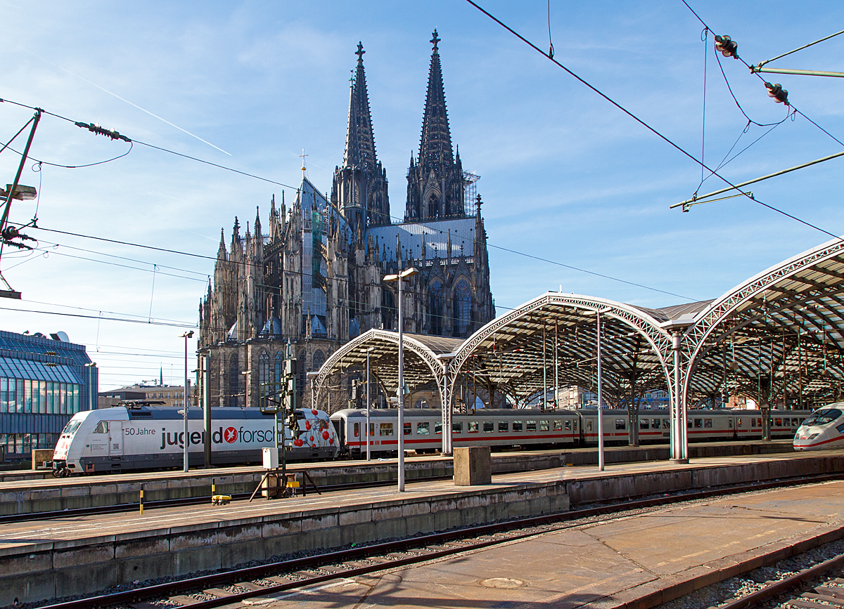 
Blick auf dem Kölner Dom vom Hauptbahnhof aus am 08.03.2015. 
Aus dem Hbf fährt gerade die 101 050-3  50 Jahre Jugend forscht  mit einem IC.