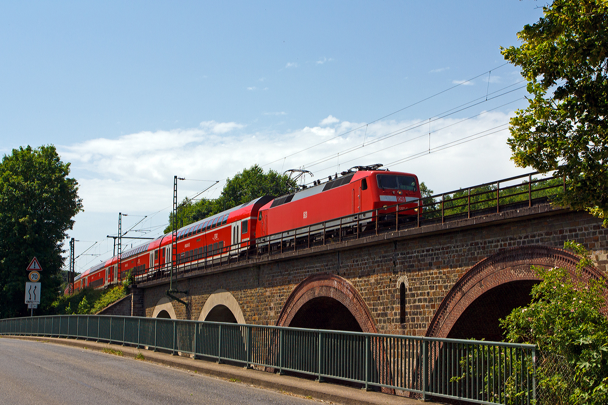 
Die 120 207-6 (ex 120 136-7) der DB Regio mit 6 DoSto´s als RE 9 - Rhein Sieg Express (RSX) Aachen - Köln - Siegen überquert am 10.06.2014 bei Au(Sieg) die Sieg und fährt in Richtung Siegen.

Die Lok wurde 1988 von Krauss-Maffei unter der Fabriknummer 19961 (die elektrische Ausrüstung ist von Siemens) gebaut und als 120 136-7 an die DB geliefert, ende 2010 wurde sie mit einem Nahverkehrspaket ausgestattet (Zugzielanzeiger, Zugabfertigungssystem, Server u. a.) und in 120 207-6 umgezeichnet. 

Wegen der erhöhten fahrdynamischen Werte bildet sie mit sechs neuen Doppelstockwagen einen Wendezug (anstelle von fünf). Sie hat die NVR-Nummer 91 80 6120 207-6 D-DB.