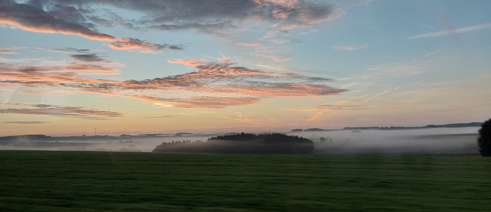 Busfahrt in den Sonnenaufgang. Zwischen Fetsch und Heisdorf hngen die Nebelschwaden ber den Bergtlern und die Wolken leuchten in voller Farbenpracht. 06.10.2023 (Jeanny)