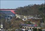 Die RB 3213 Luxembourg - Wiltz befhrt am 15.03.2013 den 70 Meter langen Grnewald Viadukt im Stadtteil Pfaffental, bevor sie die Stadt Luxemburg durch ein Tor der einstigen Festungsmauer verlsst.