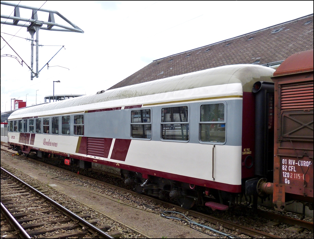 . Am 14.06.2013 konnte ich den neu gestylten Rendez-vous Wagen im Bahnhof von Luxemburg fotografieren. (Hans)

Ein kleiner Einblick in die Geschichte der Wegmann Wagen bzw. des Rendez-vous Wagens:

In den Jahren 1965 und 1967 beschaffte die CFL 60 Nahverkehrswagen bei der Firma Wegmann in Kassel. Diese Wagen  waren aus der Bauart Bnb-59 (spter Bn 719) der Deutschen Bundesbahn abgeleitet worden. Die Ausfhrung war den technischen Gegebenheiten auf dem luxemburgischen Streckennetz angepat worden. Dank ihrer universellen Ausstattung erreichten die Wagen im Planverkehr Ziele wie Lige, Amsterdam, Koblenz, Limburg (Lahn) sowie heute noch nach Blankenberge. Im Sonderverkehr wurden GAR Antreffen, Kln, Hamburg, Bremerhaven, Berlin, Budapest, Salzburg, Innsbruck, Wien Brig, Chur, Chiasso und Dijon erreicht.

57 dieser Wagen wurden bei der CFL in Anbetracht der Zunahme der Zugleistungen um 40% zwischen 1990 und 1995 generalberholt. 2 Wagen waren zuerst abgestellt ehe sie dann in Fahrradwagen (Velos) umgebaut wurden.

Der 60. Wagen wurde einer neuen Bestimmung zugefhrt: der RENDEZ-VOUS Wagen des G.A.R.

Seit seiner Grndung im Jahre 1973 organisiert der GAR (Groupement des Amis du Rail asbl) Gruppenreisen fr seine Mitglieder in enger Zusammenarbeit mit der CFL. Um den stets wachsenden Ansprchen der Teilnehmer gerecht zu werden, wurde das Verpflegungssystem immer mehr ausgebaut. Gab es anfangs lediglich kalte Getrnke, so konnten ab 1979 Kaffee und Croissants, ab 1980 belegte Brtchen und ab 1981 komplette Mahlzeiten angeboten werden.

1986 anllich der Fahrt des Sonderzuges  Carolus Magnus  nach Aachen (dem Luxemburger Volke wurde damals der Karlspreis verliehen), wurde erstmals ein Wegmann behelfsmig mit auf den Wagen zugeschnittenen Tischen eingerichtet. Diese Einrichtung sollte ab diesem Zeitpunkt bei Sonderzgen den Fahrgsten eine Entspannungsmglichkeit bieten; mit der entsprechenden Ausstattung erhielt der jeweilige Wagen den Namen  Rendez-Vous . Ein Konzept war geboren.

Ab 1987 fand planmig ein  Rendez-Vous  Wagen Eingang in die Zugbildung des Blankenberge Expre.

Da die Montage und Demontage der gesamten Ausrstung (18 Tische, sowie eine Kcheneinrichtung) vor und nach jeder Fahrt doch aufwendig war, stellte die CFL ab 1990 fr die Saison einen Wagen ganzzeitig zur Verfgung. Das System kannte einen sehr groen Erfolg und heute sind Sonderfahrten ohne das  Rendez-Vous  kaum mehr vorstellbar. Es soll hier bemerkt werden, da alle Mitglieder des GAR diese Arbeiten ehrenamtlich verrichten.

Als Ende 1994 die Generalsanierung des entsprechenden Wagens fllig war. entschlo sich die CFL, fortan einen Wagen fr diese Sondereinstze zu spezialisieren. Die Zusammenarbeit CFL/GAR fr den neuen  Rendez-Vous  Wagen konnte beginnen.

Um den zuknftigen Unterhalt rationell zu gestalten, wurde von Anfang an festgehalten, da ein Wegmann Wagen der CFL die gnstigste Ausgangsmglichkeit fr den Umbau bieten wrde.

Die Ausfhrung der Arbeiten wurde der CFL Werksttte Petingen bertragen, die elektrische Ausrstung dem Personal der Werksttte Luxemburg anvertraut. Der GAR hatte alle  Rendez-Vous  spezifischen teile zu besorgen (Kche, Gepckablagen, Bezge der Sitze, …)

Folgende wichtige Umbauten waren vorzunehmen:
- Einrichtung einer groen und funktionellen Kche mit Gasherd unter gleichzeitiger Stillegung einer der beiden frheren Einstiegsplattformen.
- Stromversorgung sowohl ber die klassische Lichtmaschine als auch (Wahlweise) durch ein 6,5 kW Dieselaggregat und entsprechende Anpassungen an den elektrischen Schaltkreisen.
- Optimale thermische und akustische Isolierung des Wagens.
- Anpassung des Heizungssystems.
- Verlegen eines speziellen rutschhemmenden Bodens.
- Einbau fester Tische zwischen den Sitzen mit Befestigung an der Seitenwand und Absttzung auf einem Bein am Boden.
- Zustzliche Beleuchtung (umschaltbar) durch elektrische Tischlampen.
- Beziehen der Sitze mit Stoff.
- Umbau der Sitze und Vernderung der Inneneinrichtung durch den Einbau von Lngsgepcktrgern.
- Einrichtung einer Garderobe fr die Mannschaft.
- Lackierung in einer besonderen, aber dennoch dem derzeit gltigen CFL Design entsprechenden   Form.
- Fr die Wnde wurden feuerfeste Platten in dunkelroter Farbe sowie rostfreier Stahl im Kchenbereich verwendet.

Es stehen maximal 66 Sitzpltze zur Verfgung. Der Wagen kann mit einer Hchstgeschwindigkeit von 140 km/h in Belgien, Dnemark, Deutschland, Frankreich, Holland, Italien, sterreich und der Schweiz eingesetzt werden.

Ende 2005 sind der Rendez-Vous Wagen sowie weitere 7 Wegmann Wagen vom Luxemburger Staat (Kulturministerium / Amt fr Denkmalschutz) als historisch wertvoll klassiert worden. Die Wagen sind aber weiterhin im Besitz der CFL. Nachdem die Revisionsfristen 2010 abgelaufen waren wurde der Wagen abgestellt.

Anfang 2012 wurden der Rendez-Vous BR457 nach Neumnster berfhrt. Der BR457 erhielt eine komplette Revision mit einem Neuanstrich.
