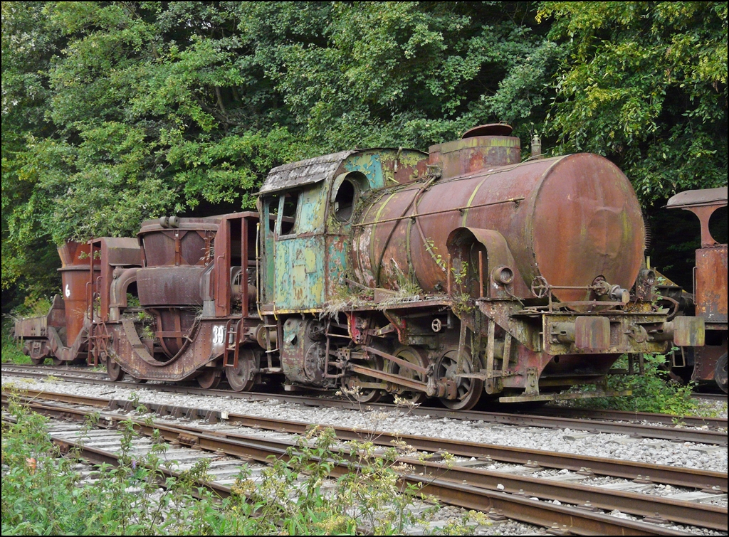 . Noch eine Jung Lok in Luxemburg - Bei der Museumsbahn Train 1900 in Fond de Gras warten noch einige Loks auf die Aufarbeitung. Am 13.09.2009 hatte ich die Gelegenheit verschiedener dieser Schtzchen abzulichten, unter anderen diese Jung Lok. (Hans)

Die technischen Daten:

Feuerlose Lokomotive V 12, dreiachsig, von ARBED Ddelingen
Erbaut im Jahre 1956 von Jung-Jungenthal Kirchen an der Sieg, Fabriknummer: 12513
Typenbezeichnung im Herstellerkatalog:  Felix 
Leistung 250 PS, Gewicht 39 t.

Der Vorteil dieser Bauart ist, dass die Ausfhrung einfach und robust ist, da das aufwndigste Teil im Hinblick auf Konstruktion und Wartung, der Dampfkessel mit seiner Feuerbchse und seinem Rohrbndel durch einen zylinderfrmigen Behlter ersetzt ist. Die Fhrung einer solchen Lokomotive ist entsprechend einfach und erfordert kein qualifiziertes Personal wir die Fhrung eines Dampfkessels. Dem Auspuff der Lokomotive entstrmt reiner Wasserdampf ohne Verbrennungsprodukte und Russ. Sie kann also ohne Belstigung im Inneren von Hallen fahren und auch ohne Gefahr in feuer- oder explosionsgefhrdeten Bereichen. Der Nachteil liegt natrlich in dem eher beschrnkten Aktionsradius und darin, dass sie auf eine stationre Kesselanlage angewiesen ist. In den Eisenhttenwerken, war Dampf sowieso fr viele andere Prozesse notwendig und daher billig verfgbar.
