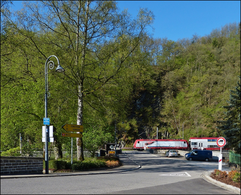 . Zwei Fotografen, eine Bildidee - Weniger Autos am Bahnbergang und weniger Huser, dafr aber mit mehr Grn, hatten zwei Fotografen weit voneinander entfernt fast dieselbe Bildidee. ;-) 

Die RB 3234 Wiltz - Luxembourg fhrt am 05.05.2013 dem Bahnhof von Kautenbach entegegen. (Jeanny)