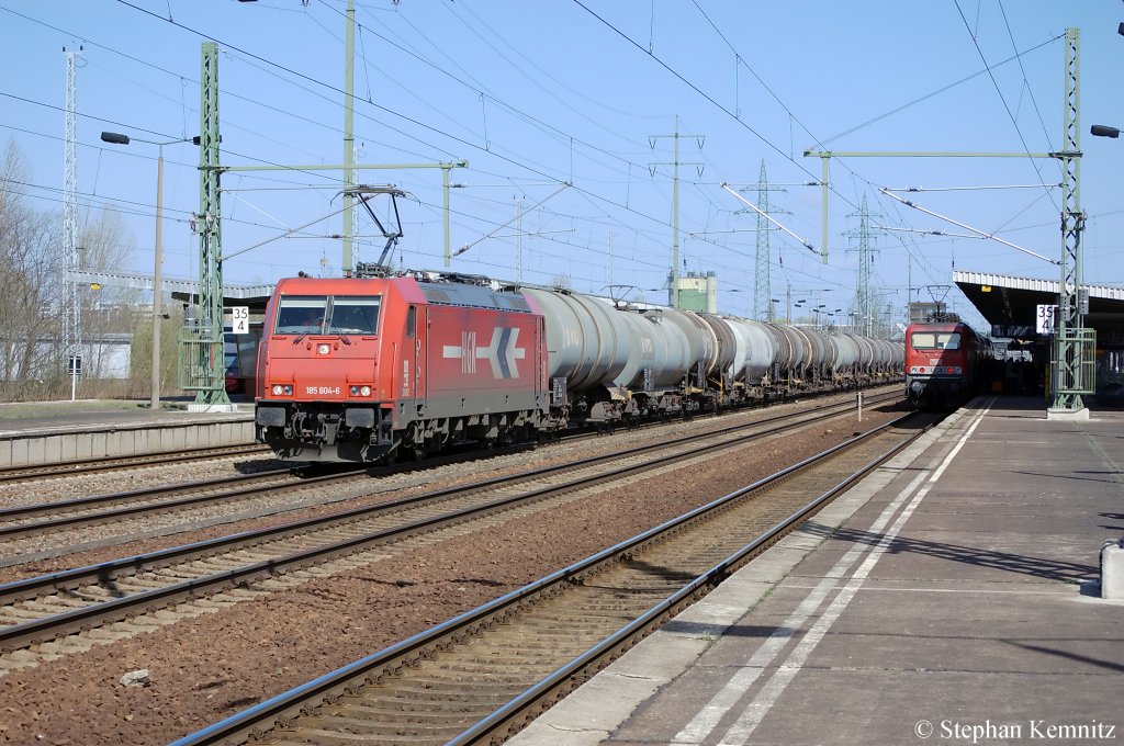 185 604-6 (HGK 2062) mit Kesselzug in Berlin-Schnefeld Flughafen. Am Bahnsteig 3 steht MEG 606 (143 864-7) mit dem RE7 (RE 18723) nach Dessau Hbf. 09.04.2011