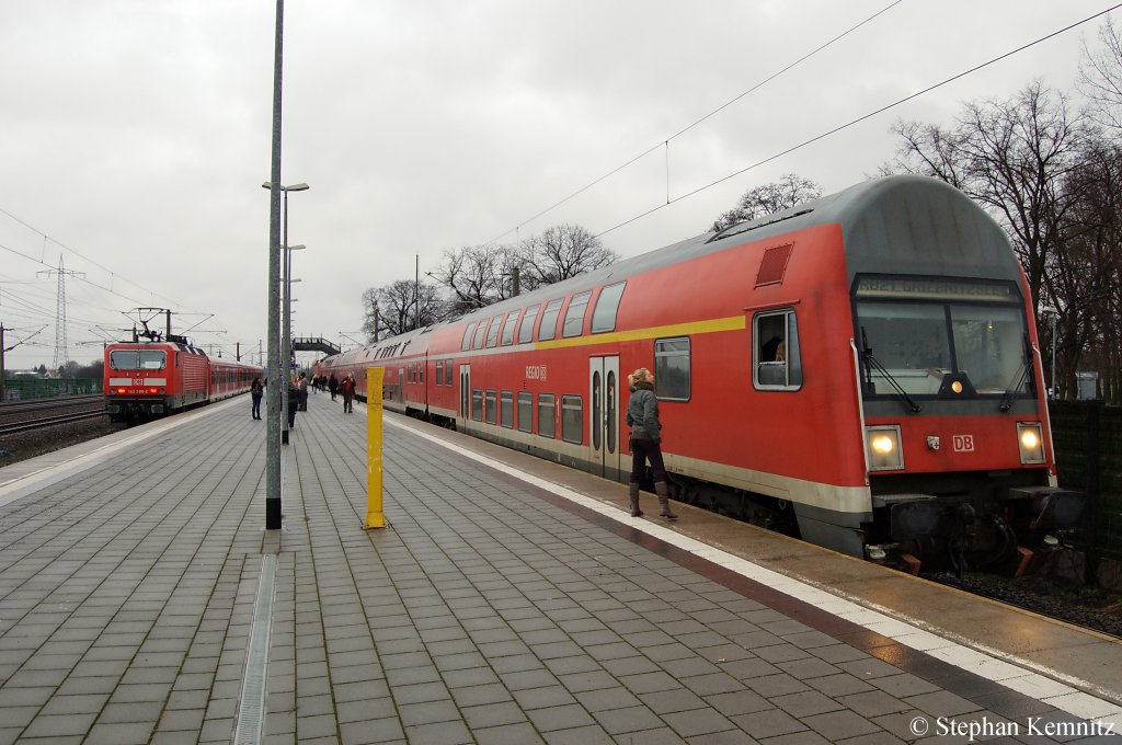 Auf Gleis 1 143 588-2 mit der RB13 (RB 28861) aus Berlin Hbf(tief) und auf Gleis 2 der RB21 (RB 18670) aus Potsdam Griebnitzsee, geschoben von der 143 221-0 in Wustermark. 14.01.2011