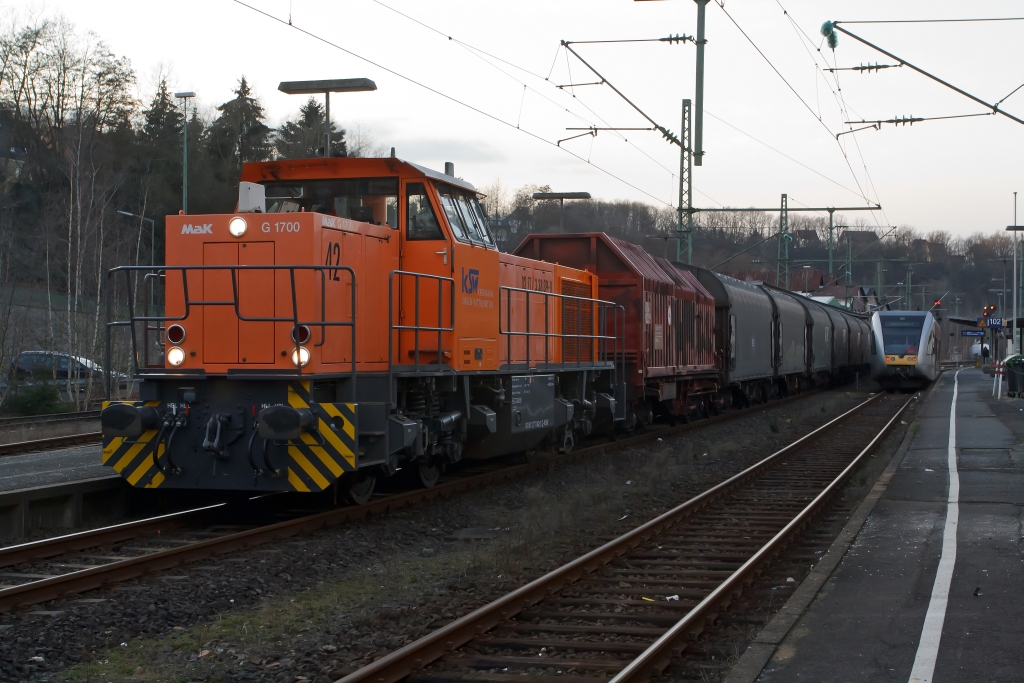 Betzdorf/Sieg am 04.02.2012: Die Hellertalbahn (Stadler GTW 2/6) ist auf Gleis 102 eingefahren, nun kann gleich auf Gleis 103 die Kreisbahn Siegen-Wittgenstein  (KSW) mit Lok 42, eine Vossloh G 1700 BB (F.-Nr. 1001108, Baujahr 2001) mit beladenen Coil-Gterzug in Richtung Herdorf losfahren. 