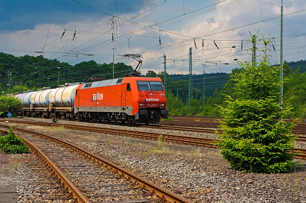 Die 152 089-9 der DB Schenker Rail Deutschland AG mit einem Kesselwagenzug, fhrt am 08.06.2013 auf der Siegstrecke (KBS 460) in Richtung Siegen, hier kurz vor dem Bahnhof Betzdorf (Sieg).
Die Lok wurde 1999 bei Krauss-Maffei (heute Siemens) unter der Fabriknummer 20216 gebaut, sie hat aktuelle NVR-Nr.  91 80 6152 089-9 D-DB und die EBA 96Q15A 089.

Die Baureihe 152
Als Ersatz fr die schweren E-Loks der BR 150 und fr Einsatzgebiete der BR 151 / 155 wurde die Beschaffung der Drehstromlok der BR 152 (Siemens ES64F) eingeleitet, sie ist eine Hochleistungslokomotive aus der Siemens ES64 EuroSprinter-Typenfamilie fr den schweren Gterzugverkehr, die auch fr Personenzge genutzt werden kann.

Die Baureihe basiert auf dem von Siemens konstruierten Prototyp ES64P. Da jedoch klar war, dass die Maschinen ausschlielich im Gterverkehr eingesetzt werden sollten und eine Hchstgeschwindigkeit von 140 km/h als ausreichend angesehen wurde, konnte auf die Verwendung von voll abgefederten Fahrmotoren verzichtet und auf den wesentlich einfacheren und preisgnstigeren Tatzlager-Antrieb zurckgegriffen werden. Dieser gilt durch die Verwendung moderner Drehstrommotoren bei niedrigen Geschwindigkeiten als relativ verschleiarm.

Technische Daten der BR 152:
Achsformel: Bo´Bo´
Lnge ber Puffer: 19.580 mm
Breite: 3.000 mm
Drehzapfenabstand: 9.900 mm
Drehgestellachsstand: 3.000 mm
Dienstmasse: 86,7 t
Hchstgeschwindigkeit: 140 km/h
Dauerleistung: 6.400 kW (8.701 PS)
Anfahrzugkraft: 300 kN
Stromsystem: 15 kV, 16 2/3 Hz
