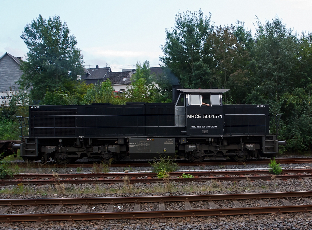 Die MRCE 500 1517, eine Vossloh G 1206, mit leeren Sammnps Flachwagen (6-achsig) Ganzzug, fhrt, am 23.08.2011, von Herdorf weiter Richtung Betzdorf. Die Lok wurde 2006 von Vossloh unter Fabriknummer 5001571 fr MRCE - Mitsui Rail Capital Europe B.V. gebaut. Sie hat die NVR-Nummer 92 80 1275 625-2 D-DISPO
