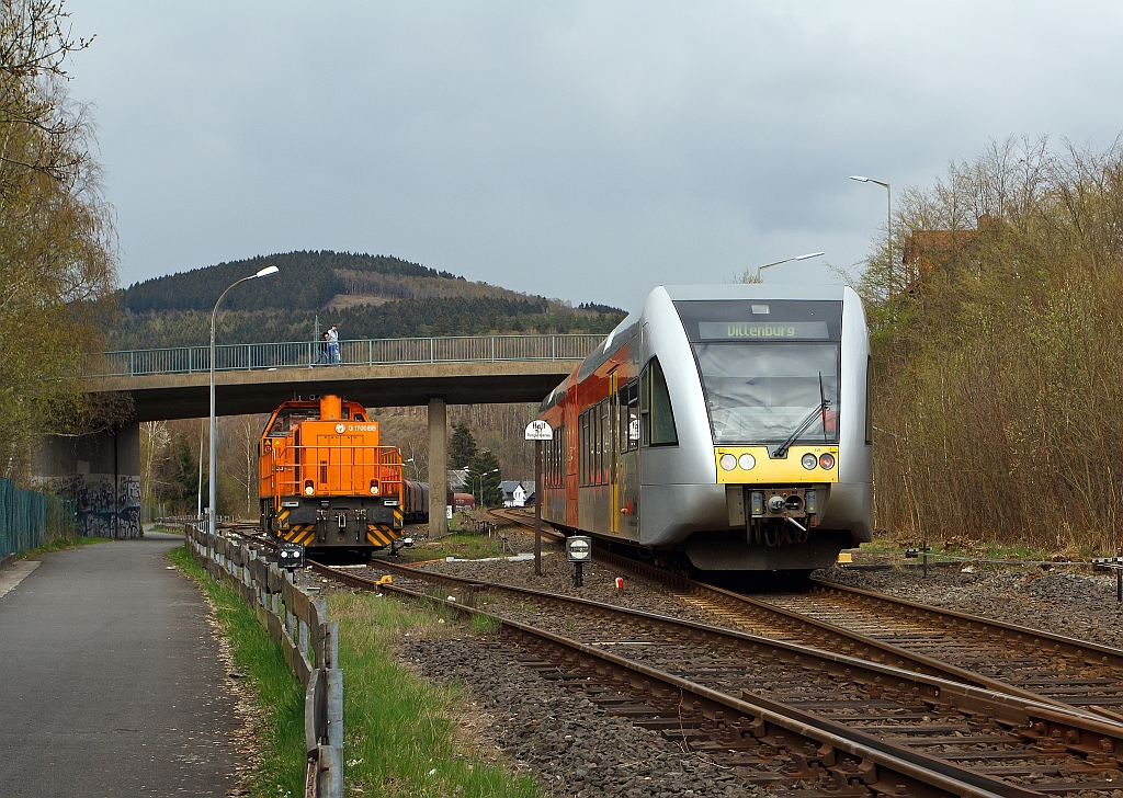 Herdorf, den 16.04.2012: Links auf dem KSW-Gleis, die Gleissperre ist noch geschlossen, steht die Lok 46 der KSW (Kreisbahn Siegen-Wittgenstein), eine Vossloh G 1700-2 BB (eingestellt als 92 80 1277 807-4 D-KSW),  mit dem Gterzug zur bergabefahrt bereit. Rechts auf dem DB-Gleis (Hellertalbahn - KBS 462) fhrt ein GTW 2/6 der Hellertalbahn in Richtung Dillenburg.