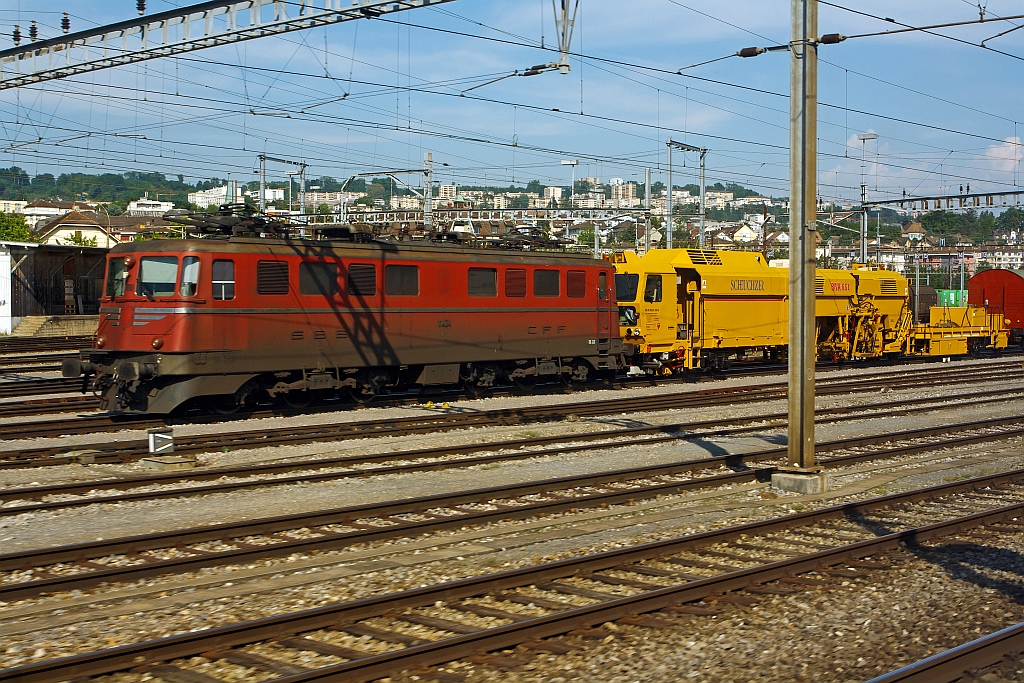 SBB Ae 6/6  (Ae 610)  11424 Kanton Neuchtel  (leider ohne Wappen) mit einem Bauzug am Haken u.a. eine MATISA Universal-Stopfmaschine BNA 661( SBB 40 85 95 81 035-5), hier am 25.05.2012 beim Bahnhof Lausanne, aufgenommen aus einem fahrenden ICN.