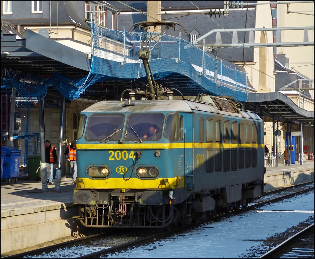 Schon vor einem Jahr lagen dunkle Schatten auf der HLE 2004, auch wenn sie auf dem Bild vom gegenberliegenden Bahnsteigsdach herrhren. Die Aufnahme enstand am 01.02.2012 in Luxemburg Stadt, als die tolle SNCB Lok auf den Abstellplatz fuhr, nachdem sie den EC 91 Vauban von Brssel nach Luxemburg gezogen hatte. (Jeanny)

Die Loks der Srie 20 sind mittlerweile fast alle aus dem Verkehr gezogen, einige dienen noch als Reserveloks und ironischerweise muss eine HLE 20 dann einspringen, wenn eine HLE 13 (die nachfolgende Baureihe fr die EC Vauban/Iris) ausfllt. 

Die Loks der Baureihe 20 wurden zwischen 1975 und 1978 in zwei Baulosen bei BN (La Brugeoise et Nivelles) in Nivelles gebaut. Der elektrische Teil der Lok stammt von ACEC (Ateliers de contruction lectriques de Charleroi). Das erste Baulos umfate in den Jahren 1975 und 1976 die ersten fnfzehn Lokomotiven dieser Baureihe. 1977 und 1978 wurde eine zweite Serie mit zehn Loks gefertigt. Als letztes Fahrzeug ging 2025 Anfang 1978 in Dienst. Numeriert wurden die Loks fortlaufend von 2001 bis 2025.

Im elektrischen Teil sind die Loks mit einer Thyristorsteuerung ausgestattet, die aus einem fehlgeschlagenen Versuchsaufbau einer Viersystemlok hervorgegangen ist. Mit ihrer beachtlichen Leistung von ber 5.000 kW war die Baureihe 20 in der Mitte der siebziger Jahre die strkste thyristorgesteuerte Lok weltweit.  Die Loks der Srie 20 sind derzeit die einzigen 6-Achser im Bestand der SNCB. Die HLE 20 drfen nicht in Doppeltration fahren, da ihre Leistung beim Anfahren so gro ist, dass das Risiko besteht, dass die Halterung zwischen der zweiten Maschine und dem ersten Wagen bricht.

Ihren Einsatz sollten die Loks im schweren Personen- und Gterverkehr finden. Speziell auf der anspruchsvollen Strecke von Brssel ber Namur nach Luxemburg sollte die Lok ihre Strke ausspielen. 

Der Steckbrief der Srie 20:

Baujahr: 1975-1978
Nummerierung: 2001-2025
Stckzahl: 25
Hersteller: BN und ACEC
Lnge ber Puffer: 19504 mm
Hhe: 4185 mm
Dienstgewicht: 	111 t.
Maximale Achslast: 18,34 t.
Dauerleistung: 	5.150 kW
Stromsystem: 3kV Gleichstrom
Hchstgeschwindigkeit: 160 km/h
Achsfolge: Co'Co'
 
