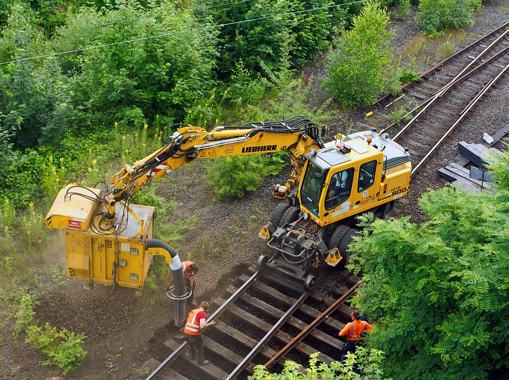 
Wie einfach man Schotter zwischen den Schwellen heraus bekommt - Mit Saugbagger  Saugstar   an Liebherr Mobilbagger A 900 C ZW der KAF Falkenhahn (Kreuztal) am 05.07.2012 in Betzdorf (Sieg) im Einsatz. Das Anbaugerät fast 1 qm Aushub bzw. Schotter, wenn es gefüllt ist, schwenkt der Bagger es über die Abladestelle (neben den Gleis, auf LKW oder Wagon). Dann wird die Bodenklappe hydraulisch geöffnet und der Aushub fällt heraus.