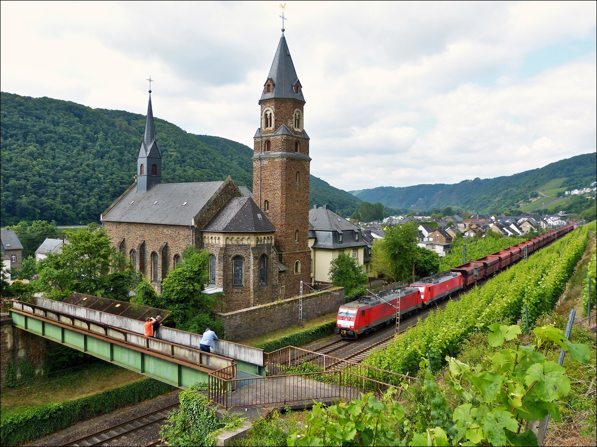 . Gleich drei Bahnfotografen stehen am 21.06.2014 auf der Fugngerbrcke in Hatzenport, um die 189 039-1 mit ihrer Schwesterlok und dem leeren Erzzug abzulichten, als diese an der katholischen Kirche St. Rochus in Hatzenport vorbeifhrt. (Jeanny)