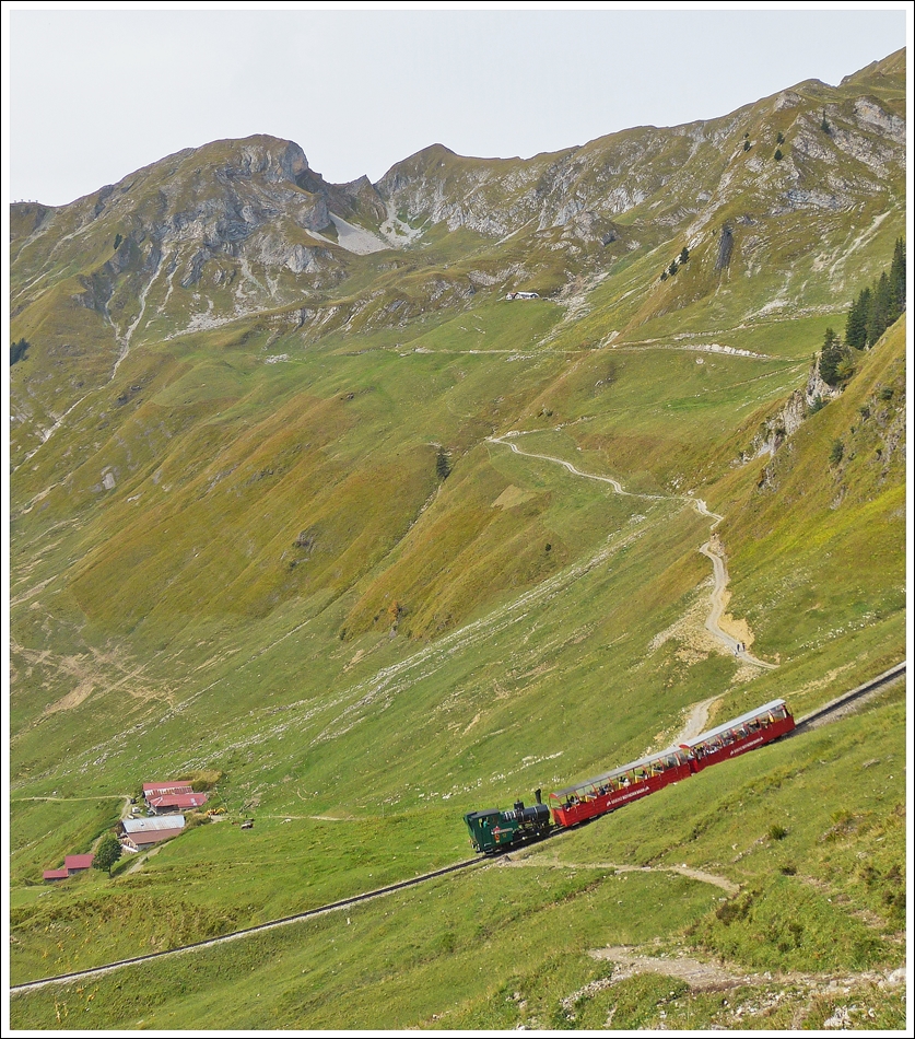 . Kurz bevor sie am 28.09.2013 die Khmatt Galerie (40 m) und den gleichnamigen Tunnel (92 m) erreicht, ist die lbefeuerte Lok N 12 mit ihren SIG-Personenvorstellwagen an einem der steilsten Teilstcke der BRB Strecke unterwegs. (Jeanny)