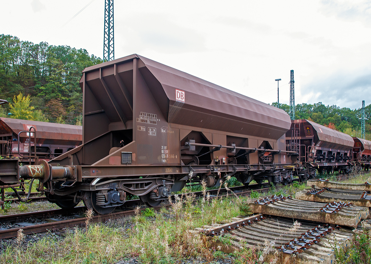 
4-achsigiger offener Drehgestell-Schüttgutwagen mit dosierbarer Schwerkraftentladung der DB Cargo AG, 31 80 6948 566-8 d-DB, der Gattung Facns 133, abgestellt am 19.10.2019 in Betzdorf (Sieg).

Der Wagen wurde 1996 unter der Fabriknummer 2555 von Linke-Hofmann-Busch GmbH (LHB) in Salzgitter-Watenstedt gebaut. 

Da bleibt nichts übrig: Bei den offenen Selbstentladewagen hat der Laderaum die Form drei nebeneinander stehender Trichter. Der Entladevorgang erfolgt über die Schwerkraft des Ladegutes. Jeweils drei Auslauföffnungen mit Drehschiebern je Längsseite ermöglichen die restlose Entladung des Wagens nach der einen oder anderen Seite. Die Menge ist regulierbar - so wie es zum Beispiel beim Einschottern oder für die Entladung über Förderband erforderlich ist. Geeignet sind die Wagen für den Transport nicht nässeempfindlicher Güter in loser Schüttung. Die Drehschieber über einer Einrichtung auf der Bühne an einer Stirnseite des Wagens können einzeln bedient werden.

Der Wagen eignet sich für die Beförderung von Schüttgütern aller Art, die nicht nässeempfindlich sind. Die regelbare Entladung ermöglicht die Beschickung von Förderbändern. Die schwenkbaren Auslaufrutschen gestatten den Einsatz des Wagens für Bunkerentladung. Gegenüber Fc-Wagen früherer Bauarten ist das Ladevolumen auf die Tragfähigkeit für speziell schwere Ladegüter (Baustoffe) abgestimmt.
Für die Kastenbleche wurde Chromstahl 1.4003 verwendet.
In jeder Seitenwand sind drei Rundschieber angeordnet. Die Schieber werden mit Handhebeln geöffnet und geschlossen. Durch eine Klinkensperre können Schieberöffnungen bis zu 160 mm in Abstufungen von 20 mm und außerdem die volle Schieberöffnung von 380 mm eingestellt werden. Es sind insgesamt 8 Schieberstellungen möglich.

TECHNISCHE DATEN:
Hersteller: Linke-Hofmann-Busch GmbH (LHB), heute Alstom
Spurweite: 1.435 mm (Nornalspur)
Achsanzahl: 4 in zwei Drehgestellen
Länge über Puffer: 16.000 mm
Drehzapfenabstand: 10.960 mm
Achsabstand im Drehgestell: 1.800 mm
Drehgestell-Bauart: Y 25 Lsd 1 - 628
Laderaum: 55 m³
Höchstgeschwindigkeit: 100 km/h (beladen) / 120 km/h (leer)
Maximales Ladegewicht: 68 t (ab Streckenklasse D)
Eigengewicht: 21.950 kg
Kleinster bef. Gleisbogenradius: R 75 m
Verwendungsfähigkeit: RIV
