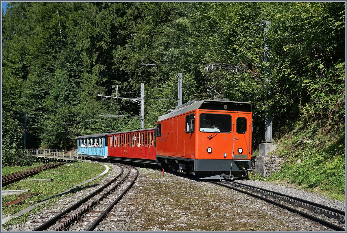 Aus Anlass des Jubiläums 125 Jahre Rocheres de Naye Bahn bietet die Zahnradbahn z.Z. täglich zwei Zugspaare unter dem Titel  La Belle Epoque fait son retour  an. Dieses Bild zeigt die He 2/2 11 mit dem talwärts fahrenden Zug (Rochers de Naye ab 16.11, Montreux an 17.10) bestehend aus den zwischen 1892 und 1909 gebauten Original-Wagen M-GL BC2 und BC 16 bei der Haltestelle le Tremblex. 14. August 2017