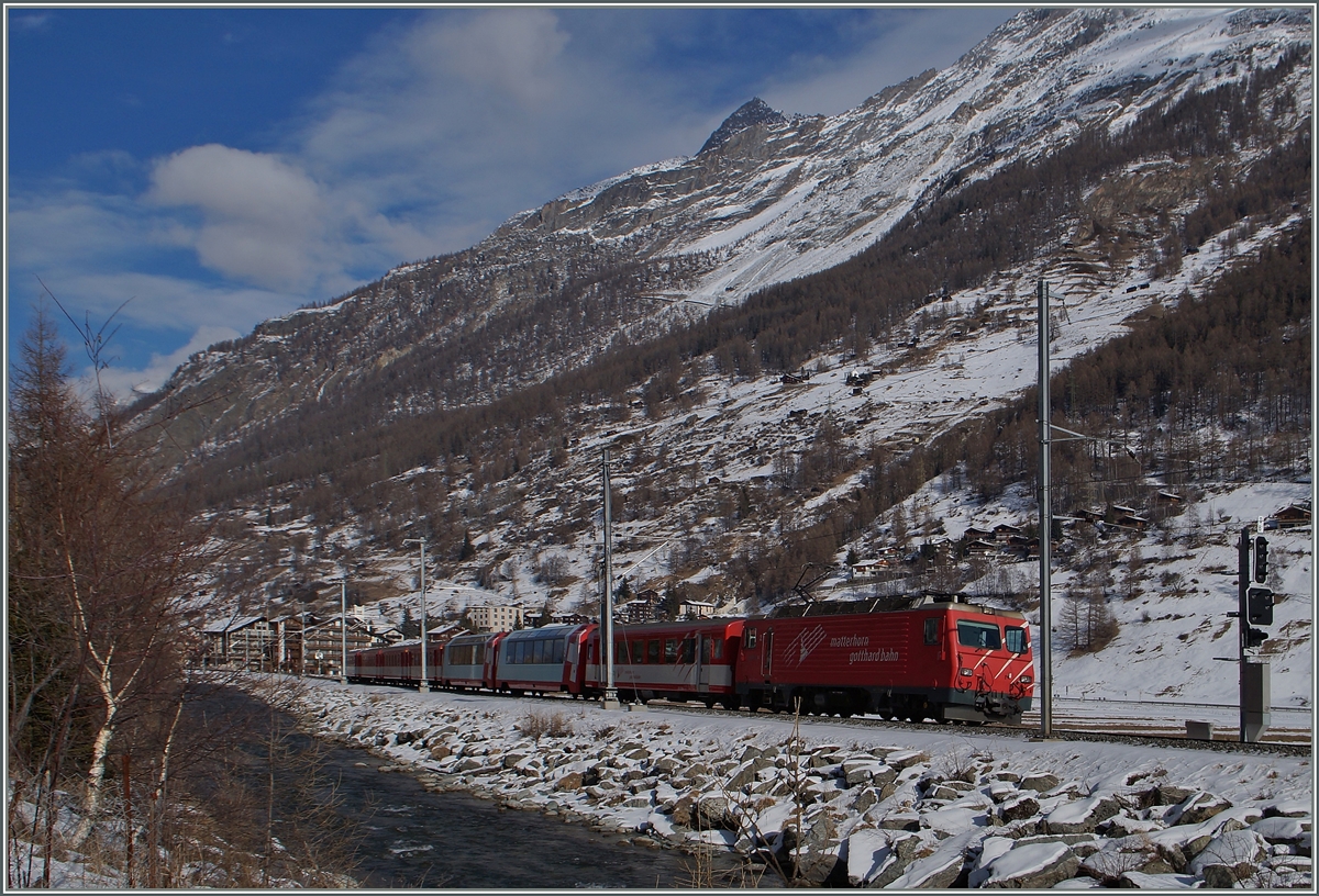 Bei überraschend wenig Schnee fährt eine MGB HGe 4/4 mit ihrem Reisezug kurz nach Täsch Zermatt zu. 
28. Jan. 2015