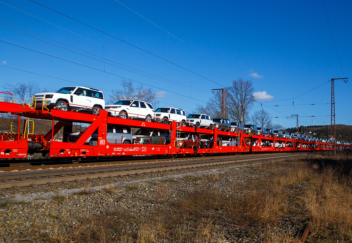 Beladener vierachsiger Doppelstock-Autotransportwagen 25 80 4382 137-4 D-ATG der Gattung Laaeffrs 561 der DB Cargo Logistics GmbH (ex ATG Autotransportlogistic GmbH) am 27.02.2021 im Zugverband bei der Durchfahrt in Rudersdorf (Kr. Siegen) an der Dillstrecke (KBS 445) in Richtung Siegen.

Die Wagen der Gattung Laaeffrs 561 sind im Rahmen von dem Projekt „Innovativer Güterwagen“ neuentwickelte Wagen. Es ist auch die Antwort auf den sich verändernden Automobilmarkt, auf dem zunehmend größere und schwerere Fahrzeuge gefragt sind (SUV). So eignen sich diese Wagen insbesondere für den europaweiten Transport von großvolumigen Pkws, SUVs und Vans, auch bei kleineren Lichtraumprofilen. Mit der hohen Lastgrenze von 35,5 Tonnen ist der Transport von besonders schweren Fahrzeugen möglich.

Damit sowohl ein typenreiner Transport als auch eine Mischverladung in den unterschiedlichen Lademaßen möglich ist, kann die obere Ladeebene hinsichtlich der Transportstellungen stufenlos eingestellt werden. Flexible Elemente der unteren Ladeebene sowie eine spezielle Geometrie der oberen Ladeebene dienen zusätzlich der effizienteren Ausnutzung des Laderaums bei besonders hohen Pkw.

Zur Ladungssicherung befinden sich auf der oberen und unteren Ladeebene jeweils 32 Radvorleger. Eine Besonderheit ist auch die erhöhte Arbeitssicherheit durch das Klappgeländer auf der oberen Ladeebene.

Die Vorteile auf einen Blick:
– Zweigliedriger, doppelstöckiger Autotransportwagen
– Hohe Lastgrenze
– Große Durchfahrhöhe
– Obere Ladeebene flexibel einstellbar
– Untere Ladeebene mit verstellbaren Elementen für eine höhere Auslastung
– Verringerte Gesamthöhe durch besondere Geometrie der oberen Ladeebene
– Klappbare Absturzsicherung auf der oberen Ladeebene

TECHNISCHE DATEN:
Gattung: Laaeffrs 561
Baujahr: ab 2019
Hersteller (u.a.): Tatravagónka a.s. Poprad (Slowakei)
Spurweite: 1.435 mm
Anzahl der Achsen: 4
Länge über Puffer : 33.000 mm
Ladelänge : 32.080 mm (unten) / 32.550 mm (oben)
Ladebreite : 2.950 mm (unten) / 2.794 mm (oben)
Wagenhöhe: 3.500 mm
Abstand der äußeren Radsätze: 27.300 mm (10.700 / 5.900 / 10.700 mm)
Laufraddurchmesser (neu): äußere 760 mm und mittlere 730 mm
Höchstgeschwindigkeit: 100 km/h (120 km/h leer)
Eigengewicht: 36.510 kg
Nutzlast: 35,5 t ab Streckenklasse B (max. 18 t pro Ebene)
Max. Gewicht je Pkw: 2.800 kg
Kleinster befahrb. Gleisbogenhalbmesser: R 75 m
Höhe des Klappgeländers: 1.100 mm 
Bermse: KNORR KE-GP-A, 2x10“
Intern. Verwendungsfähigkeit: TEN - GE 