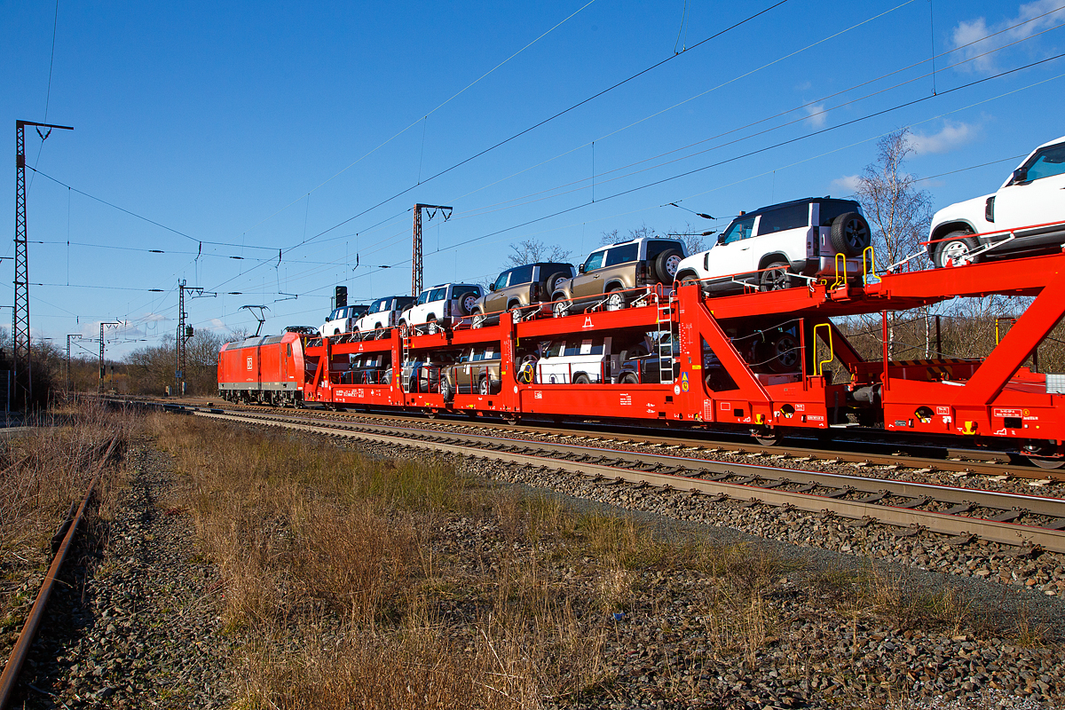 Beladener vierachsiger Doppelstock-Autotransportwagen 25 80 4382 030-1 D-ATG der Gattung Laaeffrs 561 der DB Cargo Logistics GmbH (ex ATG Autotransportlogistic GmbH) am 27.02.2021 im Zugverband bei der Durchfahrt in Rudersdorf (Kr. Siegen) an der Dillstrecke (KBS 445) in Richtung Siegen.

Die Wagen der Gattung Laaeffrs 561 sind im Rahmen von dem Projekt „Innovativer Güterwagen“ neuentwickelte Wagen. Es ist auch die Antwort auf den sich verändernden Automobilmarkt, auf dem zunehmend größere und schwerere Fahrzeuge gefragt sind (SUV). So eignen sich diese Wagen insbesondere für den europaweiten Transport von großvolumigen Pkws, SUVs und Vans, auch bei kleineren Lichtraumprofilen. Mit der hohen Lastgrenze von 35,5 Tonnen ist der Transport von besonders schweren Fahrzeugen möglich.

Damit sowohl ein typenreiner Transport als auch eine Mischverladung in den unterschiedlichen Lademaßen möglich ist, kann die obere Ladeebene hinsichtlich der Transportstellungen stufenlos eingestellt werden. Flexible Elemente der unteren Ladeebene sowie eine spezielle Geometrie der oberen Ladeebene dienen zusätzlich der effizienteren Ausnutzung des Laderaums bei besonders hohen Pkw.

Zur Ladungssicherung befinden sich auf der oberen und unteren Ladeebene jeweils 32 Radvorleger. Eine Besonderheit ist auch die erhöhte Arbeitssicherheit durch das Klappgeländer auf der oberen Ladeebene.

Die Vorteile auf einen Blick:
– Zweigliedriger, doppelstöckiger Autotransportwagen
– Hohe Lastgrenze
– Große Durchfahrhöhe
– Obere Ladeebene flexibel einstellbar
– Untere Ladeebene mit verstellbaren Elementen für eine höhere Auslastung
– Verringerte Gesamthöhe durch besondere Geometrie der oberen Ladeebene
– Klappbare Absturzsicherung auf der oberen Ladeebene

TECHNISCHE DATEN:
Gattung: Laaeffrs 561
Baujahr: ab 2019
Hersteller (u.a.): Tatravagónka a.s. Poprad (Slowakei)
Spurweite: 1.435 mm
Anzahl der Achsen: 4
Länge über Puffer : 33.000 mm
Ladelänge : 32.080 mm (unten) / 32.550 mm (oben)
Ladebreite : 2.950 mm (unten) / 2.794 mm (oben)
Wagenhöhe: 3.500 mm
Abstand der äußeren Radsätze: 27.300 mm (10.700 / 5.900 / 10.700 mm)
Laufraddurchmesser (neu): äußere 760 mm und mittlere 730 mm
Höchstgeschwindigkeit: 100 km/h (120 km/h leer)
Eigengewicht: 36.510 kg
Nutzlast: 35,5 t ab Streckenklasse B (max. 18 t pro Ebene)
Max. Gewicht je Pkw: 2.800 kg
Kleinster befahrb. Gleisbogenhalbmesser: R 75 m
Höhe des Klappgeländers: 1.100 mm 
Bermse: KNORR KE-GP-A, 2x10“
Intern. Verwendungsfähigkeit: TEN - GE 
