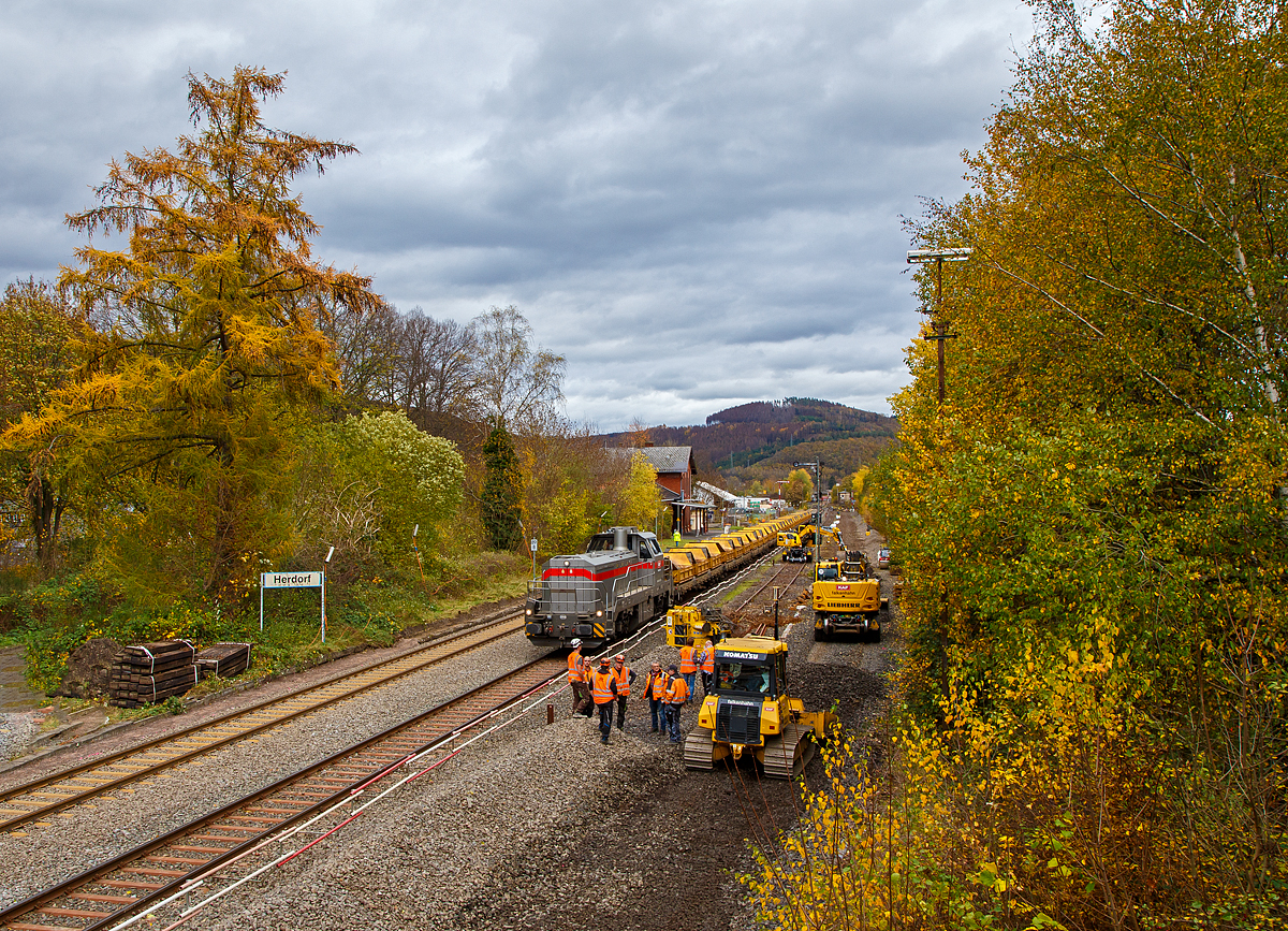 
Blick auf den Bahnhof Herdorf am 02.11.2020. Am Sonntag den 01.11.2020 war auf der Baustelle Ruhetag, heute wird wieder gearbeitet, der Oberbau von Gleis 4 wurde heute Morgen demontiert, nun hat der Aushub vom Schotterbett begonnen. Auf Gleis 2 steht die Vossloh G 12 „Karl August“ 92 80 4120 001-7 D-KAF der KAF Falkenhahn Bau AG mit einem Kippwagenzug (Kippwagen MK 45 DH „LW-Kipper“, der Gattung Rlps), der mit dem Aushub (Altschotter) beladen wird. Der Altschotter  wird später zum Recycling nach Bochum abgefahren.

Übrigens, die Lok trägt den Namen des Firmengründers Karl August Falkenhahn, der die Baufirma 1919 in Kreuztal gründete.
