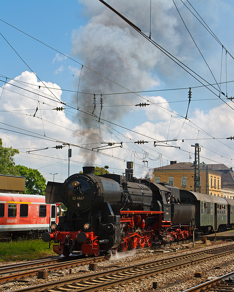 Dampfspektakel 2014 - Mir war das Gedränge auf den Bahnsteigen im Bf Neustadt an der Weinstraße einfach zu viel. 
So ging ich erst einmal ins Eisenbahnmuseum Neustadt/Weinstraße (Pfalzbahn - Museum), von hieraus konnte ich diese Aufnahme machen. 

Die Dampflokomotive 52 4867 der HEF (Historische Eisenbahn Frankfurt e. V.), ex GKB 152.4867 (Graz-Köflacher Eisenbahn- und Bergbaugesellschaft), ex ÖBB 152.4867, ex DR 52 4867, beginnt am 31.05.2014 ihre Reise mit Personenzug 79819 vom Bahnhof Neustadt (W) nach Richtung Alsenz.

Die Lok wurde 1943 bei Maschinenbau und Bahnbedarf AG in Babelsberg unter der Fabriknummer 13921 gebaut und als 52 4867 an die Deutschen Reichsbahn geliefert, nach dem Krieg verblieb sie in Österreich bis die HEF sie 1980 kaufte.

So ist diese Lok noch eine Ur-52er (keine Roko-Lok) mit Barrenrahmen.  Barrenrahmen, wie sonst allgemein bei der Deutschen Reichsbahn üblich, wurden von den Lokomotivfabriken bei den erste Lieferungen der Baureihe 52 non eingebaut. Dies aber nur solange wie noch vorgefertigte Rahmen, für die zugunsten der BR 52 eingestellte Produktion, der in den Abmessungen identischen Baureihe 50, lagerte. Später wurden sie mit geschweißtem Blechrahmen gefertigt.

TECHNISCHE DATEN der Güterzug - Dampflokomotive 52 4867: 
Hersteller: Maschinenbau und Bahnbedarf A. G. Potsdam
Fabriknummer: 13 931
Baujahr: 1943
Spurweite: 1.435 mm
Bauart: 1`E h2
Gattung: G 56.15
Treibraddurchmesser: 1.400 mm
Laufraddurchmesser:  850 mm
Länge über Puffer:  22.975 mm
Zylinderzahl: 2
Zylinderdurchmesser:  600 mm
Kolbenhub: 660 mm
Kesselüberdruck: 16 bar
Rostfläche: 3,89 m²
Verdampfungsheizfläche: 177,83 m²
Überhitzerheizfläche: 68,94 m²
Indizierte Leistung: 1.621 PS (1.192 kW)
Achslast max. : 15,3 t
Lokreibungslast:  75,5 t
Lokdienstgewicht: 84,4 t (ohne Tender)
Fahrzeugdienstgewicht: 133,1 t (mit Tender)
Wasservorrat: 30.000 l
Kohlevorrat: 8 t
Höchstgeschwindigkeit: 80 km/h (vorwärts / rückwärts)

Tender: Wannentender Typ  2'2' T 30 
Wannentender, sind  von Westwaggon in Köln, entwickelten Tender in Wannenform (daher die Bezeichnung), mit Drehgestellen und 30 m³ Wasserinhalt, sowie 10 Tonnen Kohleinhalt.