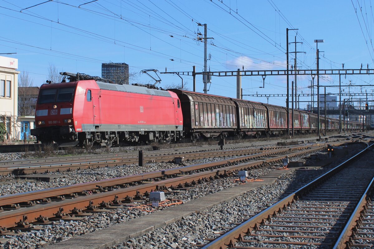 DB Cargo 185 087 schleppt ein Ganzzug für Freiburg Gbf durch Pratteln am 13 Februar 2024.