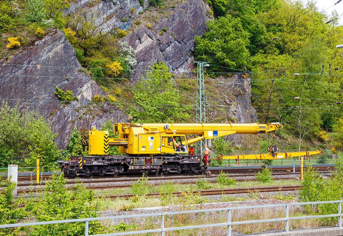 
Der 125t - KIROW Gleisbauschienenkran KRC 810 T der Hering Bau (Burbach), Schweres Nebenfahrzeug Nr. D-HGUI 99 80 9419 010-0, fährt am 09.05.2015, nach dem Ablegen einer Weiche im Hbf Siegen, nun wieder Rückwärts zum Lagerplatz um das nächste Teil zu holen.

Der Kran wurde 2013 von KIROW in Leipzig unter der Fabriknummer MT2012170324 gebaut und an die Hering Bau geliefert. Die Hering Bau gehört in Deutschland zu den größten Eisenbahnkran-Dienstleistern, sie hat 10 eigene Krane.

Der 125-t-Eisenbahndrehkran wird für den Aus-und Einbau von schweren Betonweichen, Gleisjochen und Hilfsbrücken sowie für die Montage von Ingenieurbauwerken eingesetzt. Bei Havarien auf Bahnstrecken leistet er schnelle Hilfe zum Bergen schwerer Lasten.

Technische Daten
Eigengewicht: 128 t
Länge über Puffer: 13.000 mm
Achsanzahl: 8
Drehzapfenabstand: 8.000 mm
Drehzapfenabstand im Drehgestell 1 und 2: 2.300 mm
Achsabstand in den Einzeldrehgestellen: 1.100mm
Ergebene Achsabstände in m: 1,1 / 1,2 / 1,1/ 4,6 / 1,1 / 1,2 / 1,1
Achsfolge: 1'A'1A'A1'A1'
Achslast: 16,0 t
Motorleistung: 235 kW
Fahrgeschwindigkeit im Zugverband: 100 km/h
Fahrgeschwindigkeit mit Eigenantrieb: 19 km/h
zul. Anhängelast: -
Zugelassen als Schwerwagen für Streckenklasse: CS 05
kleinster befahrbarer Radius: 00 m

Tragfähigkeiten:
bei 0,00 m Ausladung vor Puffer, mit Schwerlastausrüstung: 125 t
bei 2,80 m Ausladung vor Puffer, ± 30°, abgestützt: 90 t
bei 2,80 m Ausladung vor Puffer, ± 20°, freistehend: 46 t