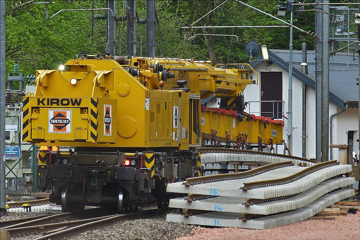 Der 150 t Kirow Gleis- und Weichenbaukran KRC 1200 der Firma Swietelsky bei Gleisbauarbeiten im Bahnhof Kautenbach. Er hat ein neues Gleisstck aufgenommen und macht sich auf den Weg in Richtung Tunnel um deas Gleisstck zu verlegen.  16.05.2016 (Hans)