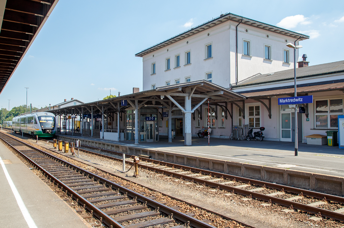 
Der Bahnhof Marktredwitz am 01.07.2015, der Bahnhof der Großen Kreisstadt Marktredwitz im bayerischen Regierungsbezirk Oberfranken. Dort kreuzen sich die beiden Hauptstrecken Nürnberg–Cheb und Regensburg–Hof.

Der Marktredwitzer Bahnhof – bei der Eröffnung noch als Bahnhof Markt Redwitz bezeichnet – ist ein wichtiger Eisenbahnknotenpunkt in Nordbayern. Er befindet sich im nordwestlichen Stadtgebiet und ist von der Innenstadt etwa fünf Gehminuten entfernt.

Der Bahnhof wurde am 15. Mai 1878 von der Bayerischen Staatsbahn zusammen mit den Bahnstrecken Schnabelwaid – Marktredwitz (heute Teilstück der Strecke Nürnberg – Cheb) und Marktredwitz – Holenbrunn (heute Teilstück der Strecke Regensburg – Hof) als Durchgangsbahnhof eröffnet. Der Ausbau zum Kreuzungsbahnhof fand mit der Inbetriebnahme des Abzweigs nach Schirnding am 20. November 1879 (später bis Cheb (Eger) verlängert, beides heute Teilstücke der Strecke Nürnberg – Cheb) und der Verbindung nach Wiesau (heute Teilstück der Strecke Regensburg – Hof) am 1. Juni 1882 statt.

Vor dem Zweiten Weltkrieg war Marktredwitz ein wichtiger Eisenbahnknotenpunkt für ganz Europa. An ihm kreuzten sich die Linien Rom – München – Berlin – Stockholm und Paris – Nürnberg – Prag. Täglich verließen über hundert Züge den Bahnhof in alle vier Himmelsrichtungen. Auch beim Fall der Mauer spielte der Marktredwitzer Bahnhof eine entscheidende Rolle. Für viele DDR-Bürger war es die erste Gelegenheit, die überfüllten Züge zu verlassen, die über Hof die Grenze passierten, oder direkt von Eger kommend, am Bahnhof Halt machten.

Bis 2006 war Marktredwitz Haltepunkt der InterCity-Verbindung Nürnberg – Hof – Dresden, seit deren Einstellung wurde Marktredwitz vom Franken-Sachsen-Express (FSX) bedient, der im Regionalverkehr die frühere IC-Linie ersetzt hat. Nach der Elektrifizierung der Strecke Reichenbach – Hof wurde auch diese Verbindung eingestellt. Seither verkehren die RE nur noch in der Relation Nürnberg – Hof.

Die einst umfangreichen Gleisanlagen wurden, wie bei vielen ehemals bedeutenden Bahnhöfen, in den vergangenen Jahren durch Rückbauten reduziert. Im Güterverkehr ist der Bahnhof als Umladebahnhof des kombinierten Verkehrs Straße-Schiene für Nordbayern von Bedeutung. Für den Personenverkehr stehen fünf Bahnsteiggleise zur Verfügung.