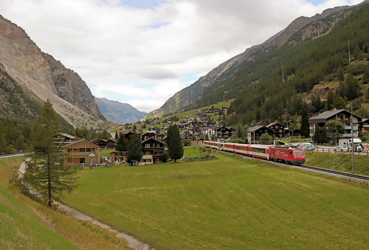 Der Bergsturz von Randa: Mit Blick auf den Bergsturz im Hintergrund kommt Lok HGe4/4 II Nr. 5 mit ihrem Zug entgegen. Bei Randa, 18.September 2024  