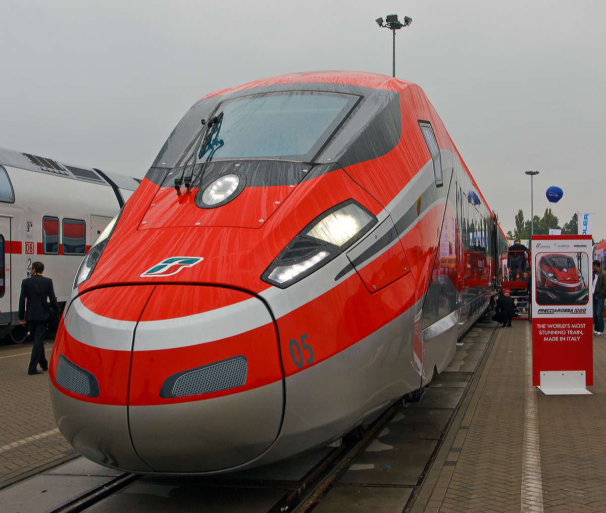 
Der neuste  Rote Pfeil  ETR 1000 (offiziell nun ETR 400), hier am 26.09.2014 prsentiert auf der Inno Trans 2014 in Berlin. Man wirbt auch mit dem Slogan „The World's most stunning Train, Made in Italy” (ich wrde es bersetzen „Dem weltweit beeindruckenden Zug, Made in Italy“)

ETR 1000, auch Frecciarossa 1000 oder V300 Zefiro, ist eine Baureihe von italienischen Hochgeschwindigkeitszgen, die durch ein Konsortium bestehend aus Bombardier Transportation und AnsaldoBreda hergestellt werden. 50 Zge sind bestellt. Die italienische Trenitalia, 100-prozentige Tochtergesellschaft der Ferrovie dello Stato Italiane (FS) will auf ihren Schnellstrecken knftig mit Tempo 360 km/h fahren.

Im Gegensatz zum ETR 500 ist die Antriebsausrstung nicht mehr in zwei Triebkpfen konzentriert, sondern ber die ganze Lnge des Zuges verteilt. Der Zug basiert auf dem Bombardier Zefiro fr China und dem AnsaldoBreda V250. Er ist ausgelegt fr einen Betrieb mit 360 km/h und soll whrend Testfahrten 400 km/h erreichen.   Zur Expo 2015 sollen im Juni 2015 die ersten vier der Zge in den Betrieb gehen, vorerst mit 300 km/h, spter mit 360 km/h. Dadurch wrde sich die Reisezeit zwischen Mailand und Rom von 3 Stunden auf 2 Stunden 15 Minuten verkrzen.

Die acht Wagen bestehenden 202 m langen Triebzge sind fr vier Stromsysteme ausgelegt. Sie knnen europaweit verkehren. Ihr Einsatz ist u.a. auch der knftigen Hochleistungsstrecke von Italien durch den neuen Brennertunnel (nicht vor 2025) nach Deutschland geplant. Die Roten Pfeile der Generatio1000 bieten in der achtteiligen Konfiguration jeweils 469 Sitzpltze sowie Abteile fr Rollstuhlfahrer.  

Mit 400 Stundenkilometer wre der ETR 1000 - Der schnellste Zug der Welt - Ein Zeichen an die Konkurrenz.

Technische Daten:
Hersteller:  Bombardier Transportation, AnsaldoBreda
Spurweite: 1.435 mm (Normalspur)
Achsformel:  Bo'Bo'+2'2'+Bo'Bo'+2'2'+2'2'+Bo'Bo'+2'2'+Bo'Bo'
Lnge:  202 m
Hhe:  4080 mm
Breite:  2924 mm
Dienstgewicht:  500 t (besetzt)
Radsatzfahrmasse:  17 t
Raddurchmesser: 920 mm (neu) / 850 mm (abgenutzt)
Hchstgeschwindigkeit:  360 km/h (geplant) / 400 km/h (Konstruktiv auf Schnellstrecken mit 25kV-Elektrifizierung)
Dauerleistung:  9.800 kW
Anfahrzugkraft:  370 kN
Beschleunigung:  bis zu 0,7 m/s
Bremsverzgerung:  bis zu 1,2 m/s
Stromsysteme:  15 kV 16,7 Hz AC (Option); 25 kV 50 Hz AC; 
1,5 kV DC und 3 kV= DC
Anzahl der Fahrmotoren:  16
Sitzpltze:  469 + 2 Rollstuhlpltze

Diese Zge haben keine Neigetechnik.
