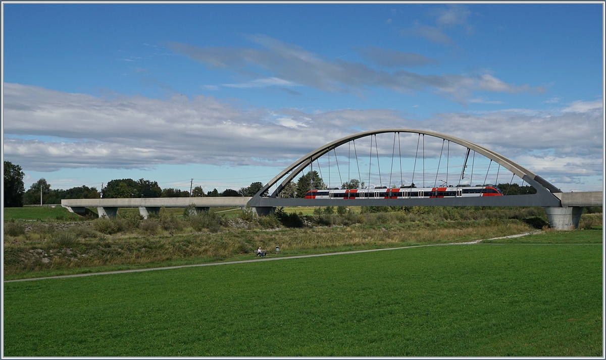 Der Rhein verbindet, der Rhein trennt; doch Brücken überwinden die Trennung. Bei Lustenau, kurz bevor der Rhein in den Bodensee fliest wird der Fluss Alpenrhein genannt, und eine neue Brücke mit einer Stützweite von 102 Meter und der Gesamtlänge, inklusiv der Vorlandtragwerke, von 276 Meter verbindet auf elegante Art das schweizerische St.Margrethen mit dem österreichischen Lustenau, und somit Zürich mit München. Im Bild, auf welchem die ganze Brücke keinen Platz fand, ein ÖBB ET 4024 als Vorarlberger S-Bahn auf der Linie Bregenz - St.Margrethen. 
23. Sept. 2018