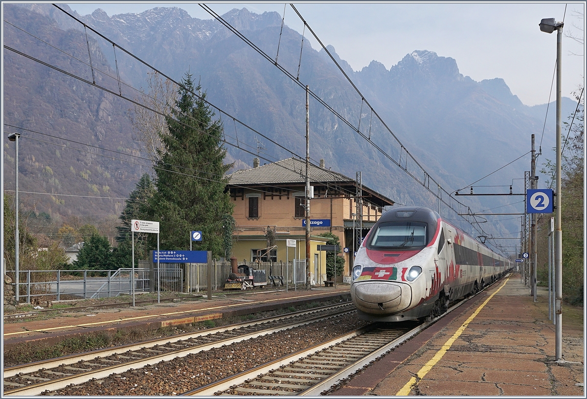 Der SBB RABe 503 022-7  Johann Wolfgang von Goethe  fährt als EC 151 von Milano nach Frankfurt durch den Bahnhof von Cuzzago Richtung Domodossola, welches in gut einer viertel Stunde erreicht wird. Auf dem Bahnsteig 1 wartet eine kleine Dampflok vergeblich auf die Weiterfahrt. 
29. Nov. 2018