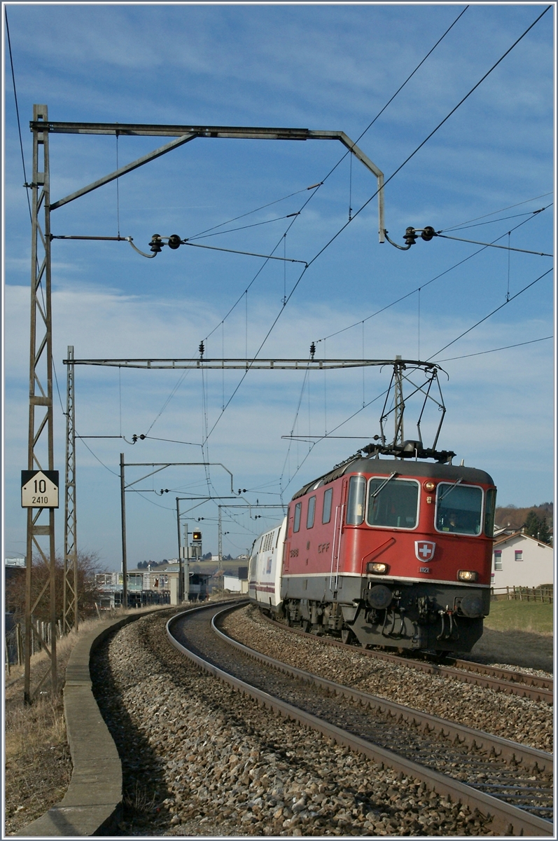 Der schöne, alte Fahrleitungsmast kommt bald weg, der Zug selbst verkehrt auch nicht mehr: Re 4/4 II 11121 mit dem EN 273 Barcelona - Zürich bei Neyruz.

12. März 2012