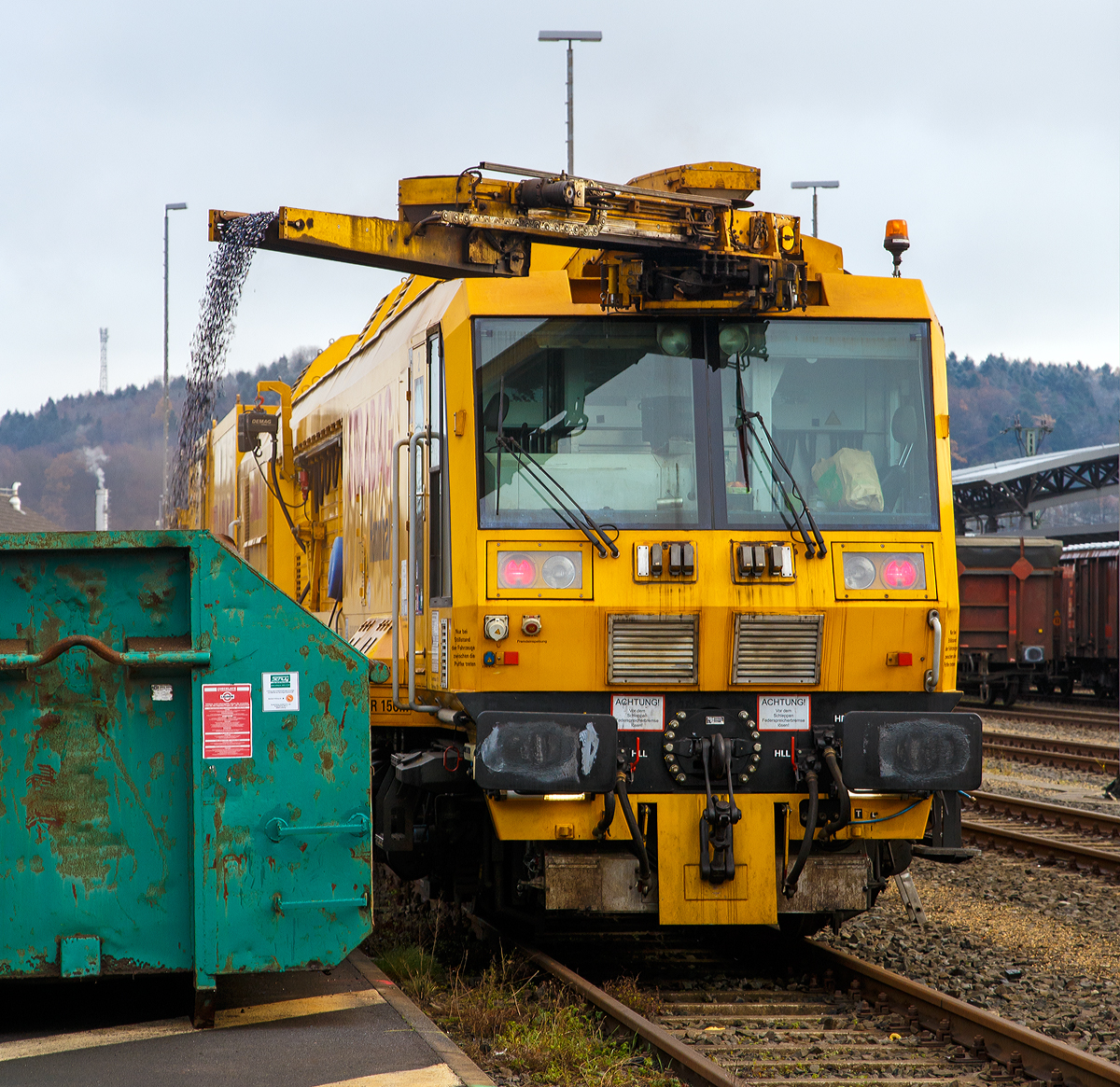 Der Strabag „Hannibal“ ein LINSINGER Schienenfrszug SF 03 W-FFS, Schweres Nebenfahrzeug Nr. 99 80 9427 003-5 D-BRS der BMTI Rail Service GmbH (Servicebetrieb der STRABAG SE) steht am 01.12.2017 beim ICE-Bahnhof Montabaur, hier laufen die Spne der Nachtschicht in einen Abrollcontainer ab.