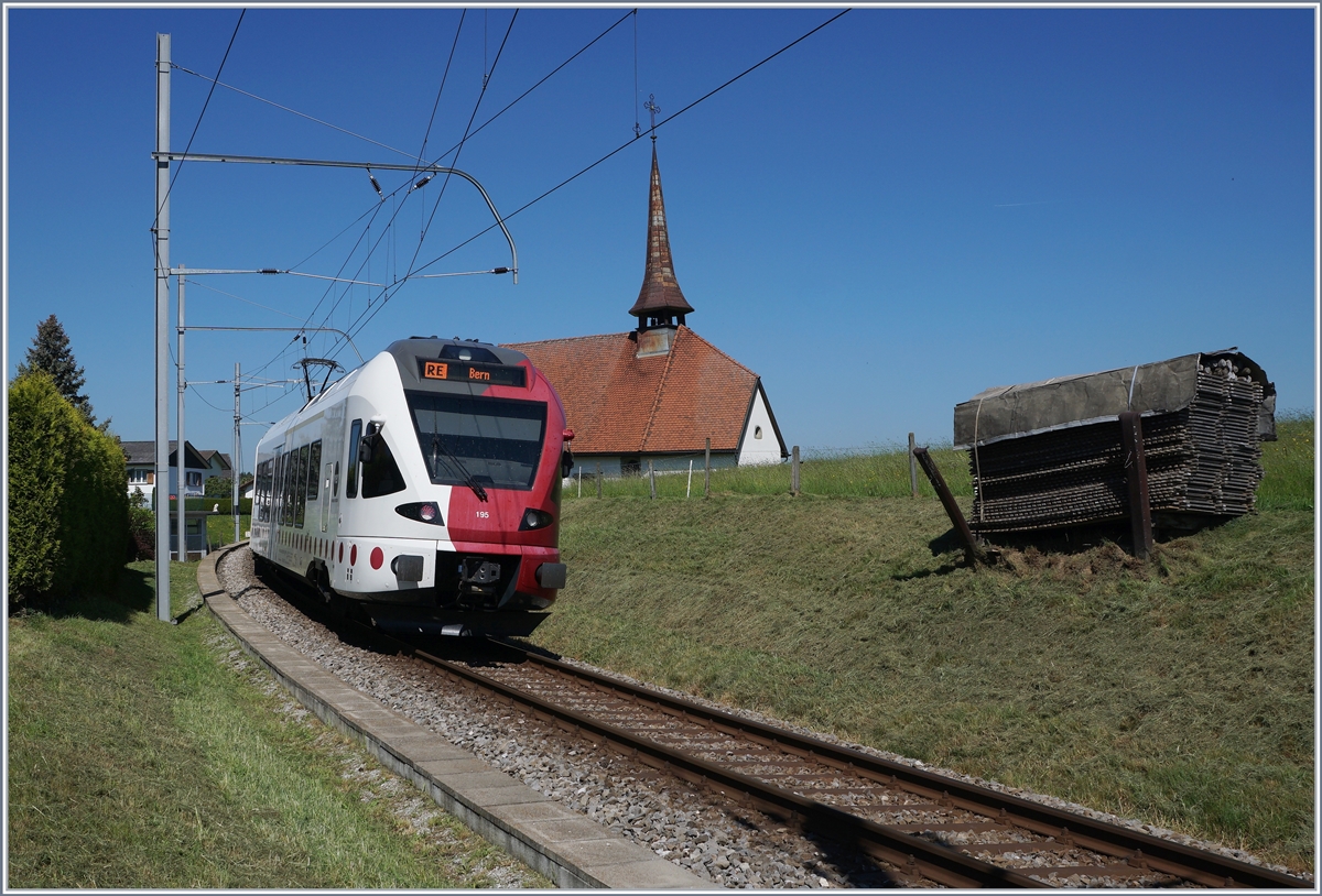 Der TPF RABe 527 195 ist bei Vaulruz auf dem Weg nach Bern, rechts im Bild , die hier typischen an den Gleisböschung stehenden Bretterstapel.

19. Mai 2020