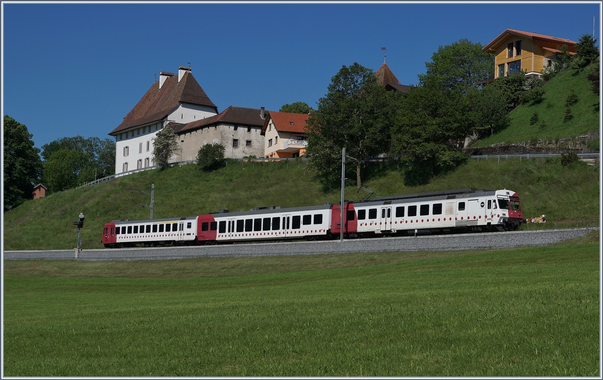 Der TPF RABe 567 182 ist bei Vaulruz auf dem Weg nach Bulle vor dem Hintergrund schmucker Gebude des Ortes. 

19. Mai 2020