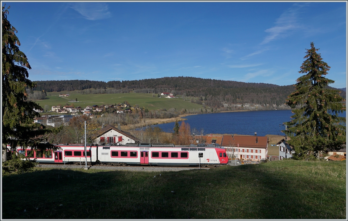 Der TRAVYS Regionalzug 6020 mit einem RBDe 560 an der Spitze beim Verlassen von Les Charbonnières.
Wenn man den Tannen im Bild (und vielen andern) glauben soll, steht ein strenger Winter bevor. Im Hintergrund des Bildes der Lac Brenet.
 
14. November 2020