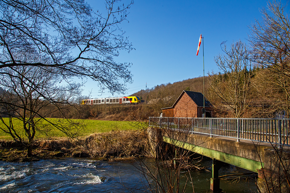 Der VT 507 (95 80 1648 107-8 D-HEB / 95 80 1648 607-7 D-HEB) der HLB (Hessische Landesbahn GmbH), ein Alstom Coradia LINT 41 der neuen Generation, erreicht am 28.02.2022 als RB 96  Hellertalbahn  (Neunkirchen - Herdorf - Betzdorf) bald den Hp Herdorf-Sassenroth. Unten im Bild die Heller (Nebenfluss der Sieg) die dem schönem Tal (Hellertal), der Bahnstrecke und der RB 96 den Namen gibt.