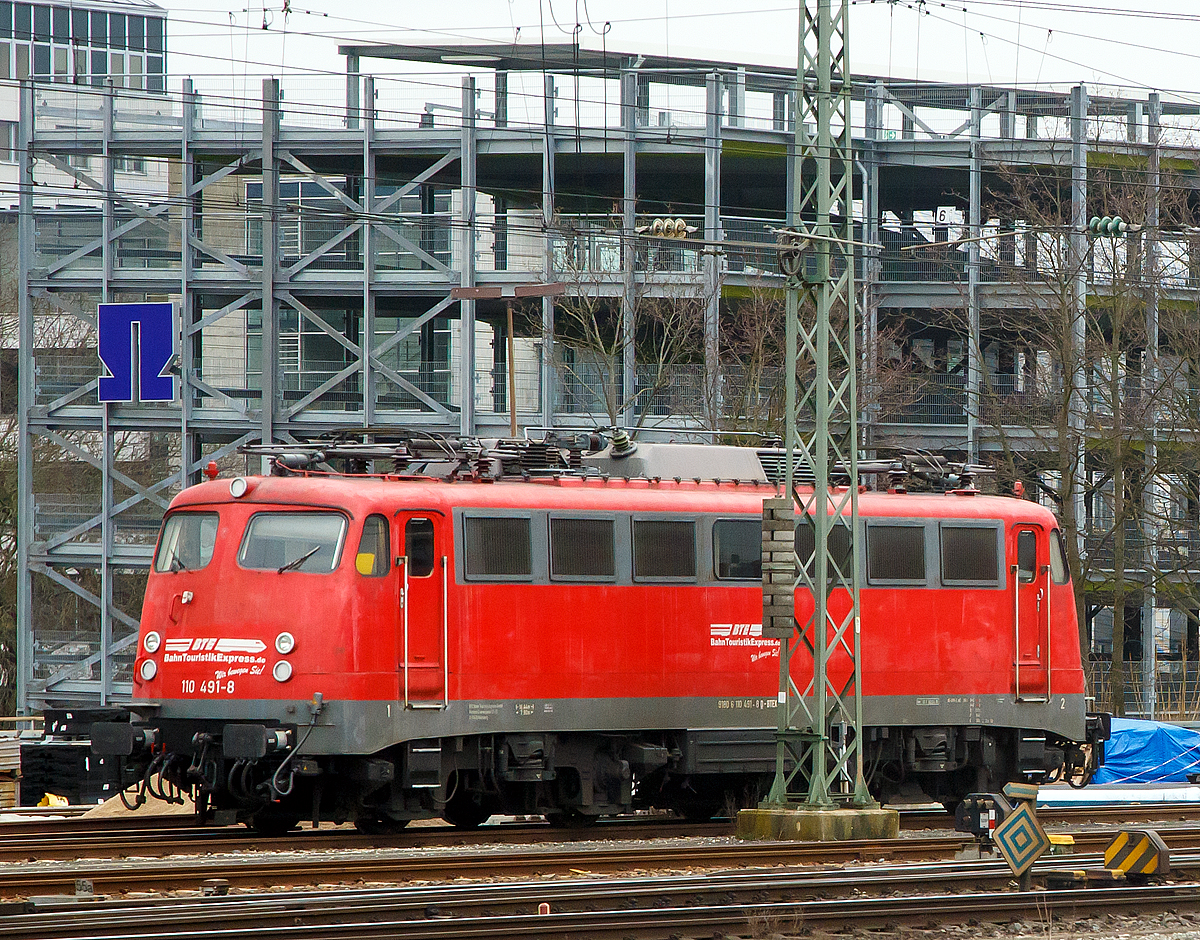 Die 110 491-8 (91 80 6110 491-8 D-BTEX) der BahnTouristikExpress GmbH (BTE), ex DB 110 491-8, ex DB 114 491-4, ex DB 112 491-6 ist am 26.03.2016 beim Hbf Nürnberg abgestellt, wo ich sie aus einem Zug heraus aufnehmen konnte. 

Die Lok wurde 1968 von Krauss-Maffei in München unter der Fabriknummer 19356 gebaut, der elektrische Teil ist von den Siemens-Schuckert-Werke (SSW), und als 112 491-6 (als eine E 10.12) an die DB ausgeliefert, 1988 wurde sie in 114 491-4 umgezeichnet. Im Jahr 1994 erfolgte der Rückbau zur 110er unter Verwendung der Drehgestelle der 110 122, somit erfolgte Umzeichnung in 110 491–8.

Die Lok gehörte 1968 zu der Serie von 20 Stück (112 485 bis 504) bei denen nicht, wie bei den anderen E 10.12, auf die teuren Henschel-Schnellfahrdrehgestelle zurückgegriffen wurde. Diese erhielten nur modifizierte Seriendrehgestelle, die sich allerdings als nicht so langlebig erwiesen haben. Infolgedessen wurden diese 112er 1988 in die Baureihe 114 umgezeichnet. 

Bei der Baureihe 114 handelte es sich um die zwanzig umgezeichneten Fahrzeuge der dritten Serie der Baureihe 112, die auf Serien-Drehgestellen der Baureihe 110 bis zu 160 km/h laufen durften. Wegen starken Verschleißes musste die Höchstgeschwindigkeit der 112 485 bis 504 ab 1985 auf 140 km/h begrenzt werden. Zur Unterscheidung von den anderen Lokomotiven der Baureihe 112, die noch 160 km/h fahren durften, wurden sie ab 1988 als Baureihe 114 bezeichnet (die Baureihennummer 113 wurde ausgelassen, da zu diesem Zeitpunkt noch die in S-Bahn-Farben lackierten Exemplare der Baureihe 111 buchhalterisch als Baureihe 113 geführt wurden).

Da auch nach der Geschwindigkeitsreduzierung weiterhin Auffälligkeiten im Bereich der Drehgestelle auftraten, wurden die Loks zunächst weiter auf 120 km/h begrenzt und kurz darauf ganz abgestellt. Unter Verwendung von Drehgestellen von Serienlokomotiven mit Ordnungsnummern kleiner als 288 wurden alle zwanzig 114er ab 1993 zu normalen 110.3 umgebaut und als 110 485 bis 504 in den Bestand eingereiht. Achtzehn der ihrer Drehgestelle beraubten »Kasten-110er« erhielten wiederum die Laufwerke ausgemusterter 140er und gingen als Teil der Baureihe 139 wieder in Betrieb, mit der sie nun aufgrund ihrer E-Bremse nahezu identisch waren. Das Konzept der Einheitslokomotive hat sich bei diesem Ringtausch voll und ganz ausgezahlt, aber nicht die Einsparung der teuren Henschel-Schnellfahrdrehgestelle.
