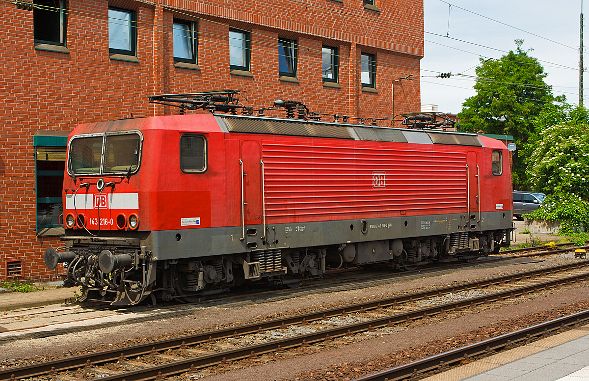 
Die 143 216-0 der DB Regio, ex DR 243 216-9, abgestellt  am 25.05.2014 beim Hbf Koblenz.

Die Lok wurde 1987 bei LEW (VEB Lokomotivbau Elektrotechnische Werke Hans Beimler Hennigsdorf) unter der Fabriknummer 18965 gebaut und als DR 243 216-9 an die Deutsche Reichsbahn geliefert, 1992 erfolgte die Umzeichnung in DR 143 216-0 und zum 01.01.1994 in DB 143 216-0. 

Ein Umbau (Einbau Notbremsüberbrückung (NBÜ) und elektropneumatischer Bremse (ep) erfolgte 2006 und 2010 die Hochrüstung auf NBÜ 2004.
Die Notbremsüberbrückung (NBÜ) dient bei Personenzügen dazu, den Zug trotz betätigter Notbremse weiterfahren zu lassen und erst an einem besser geeigneten Ort zum Stillstand zu bringen. Grund für ihre Einführung war, dass das Halten eines brennenden Zuges in einem Tunnel zu verheerenden Folgen führen kann, aber auch, dass ein Zug, der an einem schwer zugänglichen Punkt zum Stehen kommt, die Bergung erschwert. Die Notbremsüberbrückung darf vom Triebfahrzeugführer nur in besonders gekennzeichneten Streckenabschnitten angewandt werden.

Bei der NBÜ 2004 führt die Betätigung einer Notbremse allerdings zunächst nur zu einer optischen und akustischen Meldung im Führerstand. Der Triebfahrzeugführer muss diese Meldung entweder durch einen Überbrückungsbefehl oder durch eine Schnellbremsung bestätigen. Andernfalls wird die Notbremsung nach kurzer Zeit selbsttätig wirksam.

Die Lok trägt seit 2007 die NVR-Nummer  91 80 6143 216-0 D-DB und die EBA-Nummer  EBA 01C17A 216.