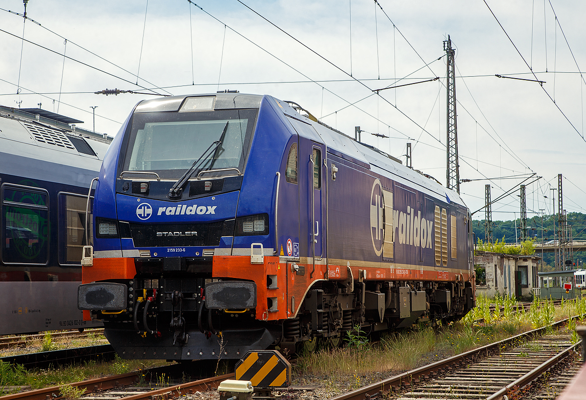 Die 159 233 (90 80 2159 233-6 D-RCM) eine sechsachsige Stadler EURODUAL der Raildox GmbH & Co. KG (geleast oder gemietet über die ELP - European Loc Pool AG, Schweiz) ist am 03.06.2022 beim Hbf Siegen abgestellt. 

Die Co'Co'- Lok wurde 2021 von Stadler Rail Valencia S.A.U. (Spanien) unter der Fabriknummer  4122 gebaut und an die ELP - European Loc Pool AG in Frauenfeld (CH) ausgeliefert. Sie hat die Zulassungen für Deutschland und Österreich.

Die neue sechsachsige Hybridlokomotive ist mehr als nur eine Lokomotive für die  letzte Meile  und bietet zwei Lösungen in einem. Sie kann auf elektrifizierten und nicht-elektrifizierten Strecken eingesetzt
werden. Während der Fahrt ist es möglich, von der elektrischen Oberleitung auf Diesel umzuschalten. Die EuroDual Deutschland / Österreich und Skandinavien können auf elektrifizierten Strecken mit 15 kV 16,7 Hz und 25 kV 50 Hz eingesetzt werden, sie haben im elektrischen Betrieb eine Leistung von 6.150 kW. Für nicht elektrifizierte Strecken besitzt die EuroDual einem leistungsstarken Dieselmotor mit 2.8 MW Leistung. Die Lokomotiven für Skandinavien verfügen über ein Winterpaket für den zuverlässigen Betrieb bei extremen Wetterbedingungen mit Schnee und Eis. Sie sind für Temperaturen bis zu -40 °C ausgelegt. 

Je nach Zugzusammenstellung kann eine einzige Co'Co'-Hybridlokomotive zwei Bo'Bo'-Lokomotiven in Doppeltraktion ersetzen. Die modernste dreiachsige Drehgestell-Technologie ermöglicht einen geringeren Verschleiß der Infrastruktur und führt dadurch zu tieferen Trassenkosten.

Technologie
• Moderne Duallokomotive für Güterzüge
• AC-Traktionssystem mit IGBT, ein Wechselrichter pro Achse
• Hohe Anfahrtszugkraft dank Einzelachsansteuerung und beste Leistung im Dieselbetrieb
• Äußerst geringe Querkräfte bei der Spurführung (nicht selbstlenkendes Drehgestell)
• Ausgerüstet mit ETCS BL3 und PZB für Deutschland oder ATC2 für Skandinavien

TECHNISCHE DATEN:
Inbetriebsetzung: 2021
Spurweite: 1.435 mm (Normalspur)
Achsanordnung: Co’Co’ 
Länge über Puffer: 23.020 mm
Drehzapfenabstand: 14.000 mm
Breite: 2.900 mm
Höhe: 4.290 mm
Achsabstand im Drehgestell: 3.600 mm (2 x 1.800 mm)
Treibdurchmesser: 1.067 mm (neu)
Eigengewicht: 123 t
Achslast: 21 t
Höchstgeschwindigkeit: 120 km/h
Elektrische Leistung am Rad bei 25 kV 50 Hz: 7.000 kW
Elektrische Leistung am Rad bei 15 kV 16.7 Hz: 6.150 kW
Leistung bei Dieselantrieb: 2.800 kW (3.807 PS)
Anfahrzugkraft: 500 kN
Elektrische Bremskraft : 240 kN

Dieselmotor: 
Motorbauart: Caterpillar  V-16-Viertakt-Dieselmotor mit Abgasturbolader und Ladeluftkühlung  vom Typ CAT C175-16
Motorleistung: 2.800 kW (3.807 PS)
Motornenndrehzahl: 1.800 U/min
Hubraum: 84,67 l (Bohrung Ø 175 mm / Hub 220 mm)
Motorgewicht (trocken): ca. 13.000 kg
Motorabmessung: 4.515 x 1.845 x 2.478 mm (l x b x h)
Abgasnorm: IIIB

Anzahl der Fahrmotoren: 6
Antrieb: elektrisch oder dieselelektrisch
Speisespannung: 25 kV 50 Hz und 15 kV 16.7 Hz
Tankinhalt Diesel: 3.500 l
Tankinhalt Urea: 400 l (für Abgasbehandlung selektive katalytische Reduktion („AdBlue“))
Bremse: KE-GP-E mZ (D)
Bremssystem Mechanisch: Pneumatisch 
Bremssystem Dynamisch: Regenerativ/Rheostatisch
Primär Federung: Schraubenfedern
Sekundär Federung: Gummi-Metall Vertikal- und Horizontaldämpfer
Zugbeeinflussung: PZB, ETCS

Quellen: ELP, Stadler Rail und CAT