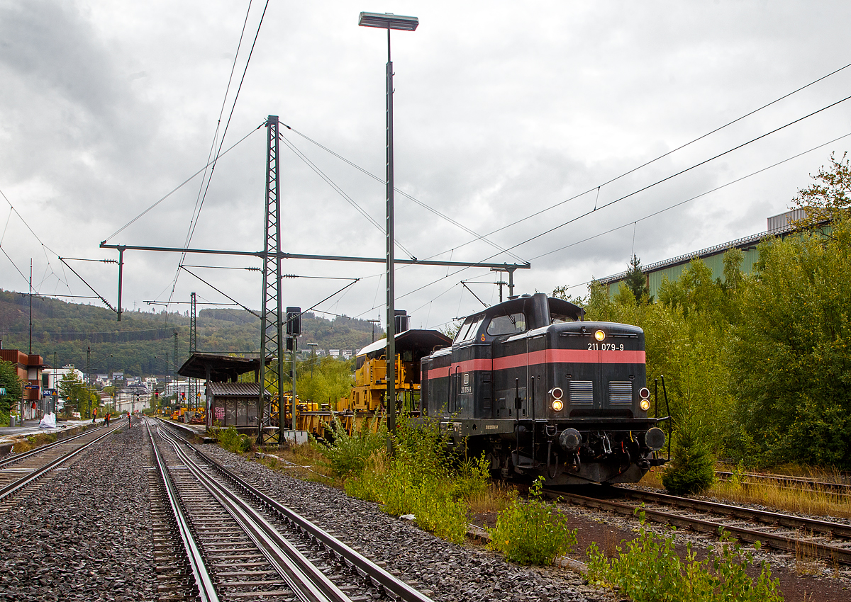 Die 211 079-9 (92 80 1211 079-9 D-JH) der JH - Joseph Hubert Bauunternehmung GmbH & Co. KG (Nürnberg), ex DB V 100 1079, am 17.09.2022 mit einem Schienenzug (Vossloh Langschienentransporteinheit STS und Schienen-Ladewagen SLW 7) beim Bahnhof Niederschelden (geografisch eigentlich Niederschelderhütte). Gleisbereich ja, aber im Gleis wurde gearbeitet und ich wurde aufgefordert das ich hier ein bild machen sollt.

Die V 100.10 wurde 1962 von MaK (Maschinenbau Kiel) unter der Fabriknummer 1000097 gebaut und als V 100 1079 an die Deutsche Bundesbahn geliefert. Zum 01.01.1968 erfolgte dann die Umzeichnung in DB 211 079-9, als diese fuhr sie bis zur Ausmusterung 1995. Im Jahr 2000 ging sie an die HEF - Hammer Eisenbahnfreunde e. V., 2015 an Redler-Service (92 80 1211 079-9 D-RAILS), in Jahr 2019 ging sie dann an die jh - Joseph Hubert Bauunternehmung.

Auf der Siegstrecke (KBS 460) erfolgen zwischen dem 16.09. bis zum 09.12.2022 in verschiedenen Anschnitten und Zeiträumen umfangreiche Umbauarbeiten. Hier zwischen Siegen und Betzdorf zwischen dem 16.09. bis zum 05.10.2022. Die DB Netz AG investiert über 12 Millionen Euro in moderne Infrastruktur.

Die V100.10  (BR 211) haben eine12-Zylinder-Viertakt-Dieselmotor mit etwas geringerer Leistung gegenüber der V 100.20. Da die V 100.10 (BR 211) für den leichten Reise- und Güterzugdienst auf Nebenstrecken vorgesehen war. Bei den V 100.10 kam überwiegend der Maybach MD 650 1B und der Daimler-Benz MB 820 Bb zum Einsatz, seltener war der MAN L 12 V 18/21 zu finden. Die Nennleistung lag bei 809 kW (1100 PS).

TECHNISCHE DATEN:
Spurweite: 1.435 mm
Achsfolge: B'B'
Eigengewicht: 63,0 t
Länge über Puffer: 12.300 mm
Drehzapfenabstand: 6.000 mm
Achsstand im Drehgestell: 2.200 mm
größte Breite: 3.115 mm
größte Höhe über Schienenoberkante: 4.275 mm
kleinster befahrbarer Gleisbogen: 100 m
Treibraddurchmesser: 950 mm
Höchstgeschwindigkeit: 100 km/h
Antrieb: dieselhydraulisch
Leistung:	809 kW (1.100 PS)
Nenndrehzahl: 1.500 U/min
Anfahrzugkraft: 177 kN
Kraftübertragung: hydraulisch
Kupplungsart: Schraubenkupplung
