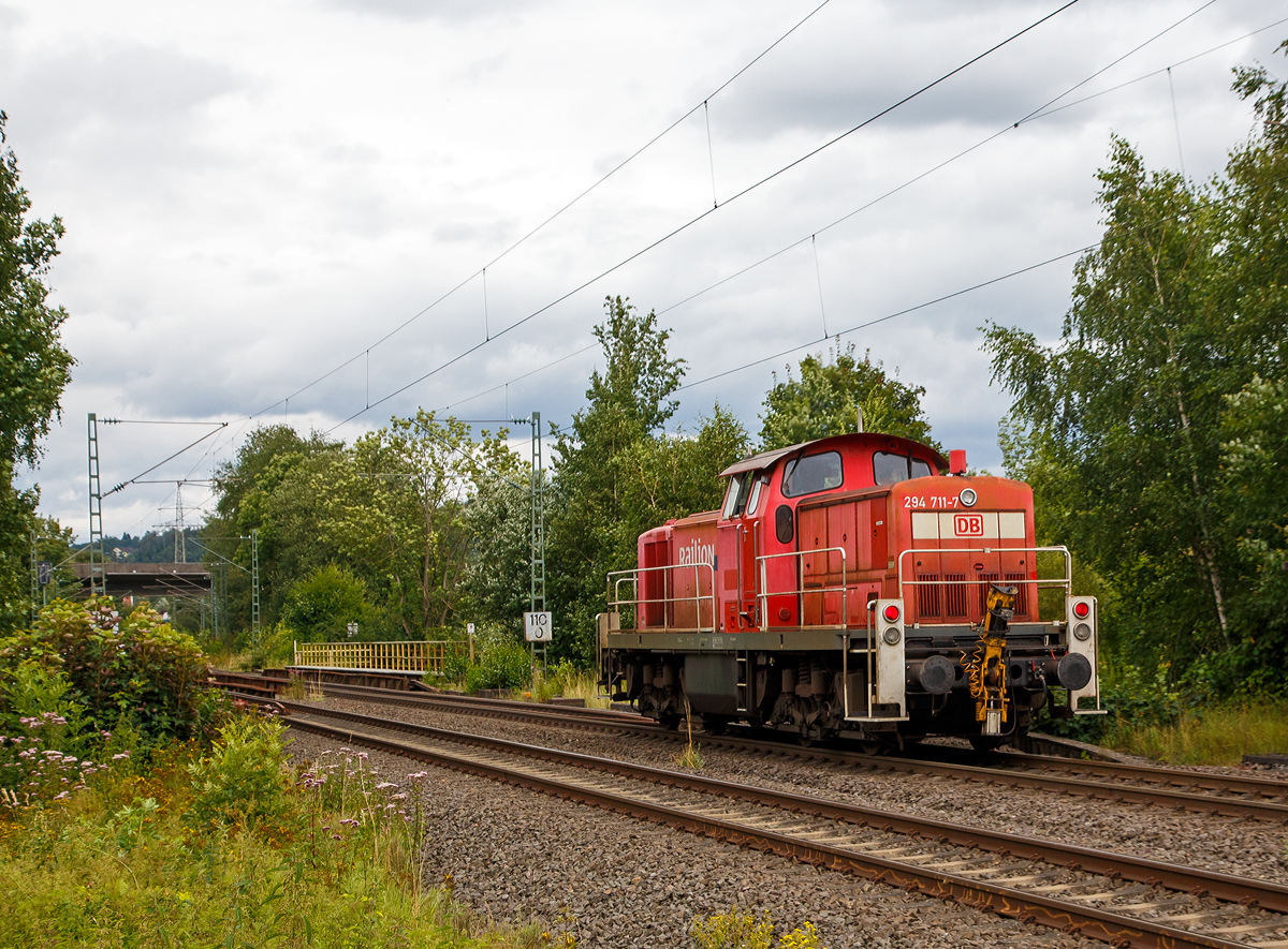 Die 294 711-7 (98 80 3294 711-7 D-DB), eine remotorisierte V 90 der DB Cargo AG fährt am 31.07.2021 als Tfzf (Triebfahrzeugfahrt) bzw. Lz (Lokzug) durch Siegen-Eiserfeld in Richtung Siegen. 

Die Lok wurde 1971 bei MaK in Kiel unter der Fabriknummer 1000519 gebaut und als 290 211-2 an die DB geliefert. Die Ausrüstung mit Funkfernsteuerung (Typ Krauss-Maffei) und Umzeichnung in 294 211-8 erfolgte 1996. Im Jahr 2003 erfolgte durch die DB Fahrzeuginstandhaltung GmbH, in Cottbus eine Remotorisierung durch einen neuen MTU 90° V-8-Zylinder-Dieselmotor mit Common-Rail-Einspritzsystem, Abgas-Turbolader und Ladeluftkühlung, vom Typ 8V 4000 R41. Der Motor ist auf eine Leistung von 1.000 kW (1.341 PS) bei 1.800 U/min gedrosselt. Auch wurden eine neue Lüfteranlage und ein neuer Luftpresser eingebaut, zudem bekam die Lok ein Umlaufgeländer.
Durch die Remotorisierung und den Umbau erfolgte auch die Umzeichnung in die heutige 294 711-7.
