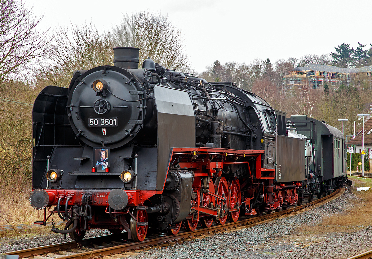 
Die 50 3501-9 des Meininger Dampflokwerkes, ex DR 50 3501-9, ex DR 50 380, am 03.02.2018 mit eine Dampfsonderzug der Eisenbahnfreunde Treysa e.V. in Hachenburg (Westerwald). 

Die heutige Werkslok des Meininger Dampflokwerkes wurde im Jahre 1940 von den Borsig Lokomotivwerken in Hennigsdorf bei Berlin unter der Fabriknummer 14970 gebaut und als 50 380 an die DRB geliefert. Nach der Rekonstruktion im Raw Stendal am 12.November 1957 wurde sie beim Bw Güsten beheimatet, wo sie elf Jahre, bis Juli 1968 im Einsatz stand. Seit 1971 ist die Lok mit einem Tender vom Typ  2'2' T26 (von Lok 50 3706) gekuppelt, dieser wurde 1941 von der Lokomotivfabrik Jung (Jungenthal bei Kirchen) unter der Fabriknummer 9288 gebaut, dieser war mit der 50 2883 geliefert worden.

Am 17. Dezember 1986 kam die 50 3501-9 ins Raw  Helmut Scholz  Meiningen. Dort erhielt sie eine L7 Ausbesserung und wurde umgebaut, um fortan als Werkslokomotive des Raw für das Neubauprogramm von Dampfspeicherlokomotiven Typ FLC zum Aufdampfen und Durchführung der Probefahrten eingesetzt zu werden. Eigens dafür wurde der Mischvorwärmer ausgebaut, eine zweite Strahlpumpe installiert und ein Rohrstutzen an der rechten Einströmung für betriebliche Heizzwecke angeordnet.

Erst mehrere Jahre später, bei einer Kesselrevision, bekam die Lok wieder einen Vorwärmer eingebaut, da sie seit geraumer Zeit wieder vorwiegend bei Sonderfahrten im Streckendienst unterwegs ist. Paradoxerweise jedoch keinen Mischvorwärmer der Bauart IfS, wie es für die Reko-Loks der DR typisch ist, sondern einen Oberflächenvorwärmer der Bauart Knorr, wie sie ihn schon vor der Rekonstrukion besaß.

Im Dezember 2007 brachte eine weitere optische Veränderung an der Maschine mit sich. Im heimatlichen Dampflokwerk wurden die kleinen Windleitbleche der Bauart  Witte  durch große Windleitbleche (Bauart „Wagner ) ersetzt. Diese trug die 50 380 auch bei ihrer Anlieferung 1940. Vom Rekokessel mit dem zugehörigen Aschkasten,  sowie den silberfarbenen Rangiergriffen an der vorderen Pufferbohle abgesehen, entspricht der optische Zustand der Lokomotive damit weitgehend dem einer Altbau-50er aus früheren Tagen.

Geschichte der BR 50:
Ende der 1930er Jahre dachte man, mit dem Stahl St 47 K-Mo einen geeigneten Kesselwerkstoff gefunden zu haben, mit dem sich der Kesseldruck auf 20 bar heraufsetzen lässt, ohne dass sich dadurch das Kesselgewicht insgesamt wesentlich erhöht. Der neu entwickelte Stahl besaß zwar eine höhere Festigkeit als die bislang verwendete Stahlsorte St 34, als Nachteil erwies sich aber die wesentlich schlechtere Wärmeleitfähigkeit. Im harten Alltagseinsatz der Dampflokomotiven ermüdete das Material dadurch sehr rasch, sodass die mit der neuen Stahlsorte angefertigten Kessel schon nach wenigen Jahren ausgetauscht werden mussten. Auch die Baureihe 50 erhielt anfänglich solche Kessel. Auch wenn ihr Zustand weniger kritisch als bei anderen Baureihen war, musste Ende der 1950er Jahre dringend für Ersatz gesorgt werden. Die Deutsche Reichsbahn ließ daher auf Grundlage des Neubaukessels der Baureihe 23.10 / 50.40 den Ersatzkessel 50E entwickeln, der wegen des abweichenden Rahmens einen 500 mm längeren Langkessel erhielt. Er wurde später auch zur Rekonstruktion der Baureihen 23, 52 zur 52.80 und 58 zur 58.30 verwendet. Zwischen November 1957 und September 1962 erhielten 208 Lokomotiven der Baureihe 50 einen solchen Kessel mit einem Mischvorwärmer, größerer Strahlungsheizfläche und verbessertem Saugzug, was auch ihre Leistungsfähigkeit erhöhte. Diese Rekolokomotiven erhielten die Baureihenbezeichnung 50.35 und die Betriebsnummern von 50 3501 bis 50 3708.

TECHNISCHE DATEN:
Nummerierung:  50 3501–50 3708
Anzahl der Rekonstruktionen : 208 (1957 bis 1962)
Spurweite:  1.435 mm (Normalspur)
Bauart: 1’E h2
Gattung:  G 56.15
Länge über Puffer:  22.940 mm
Dienstgewicht:  88,2 t  
Dienstgewicht: Lok und Tender: 140 t
Radsatzfahrmasse:  15,1 t
Höchstgeschwindigkeit: 80/50 km/h (vor-/rückwärts)
Indizierte Leistung: 1.760 PSi
Kuppelraddurchmesser:  1.400 mm
Laufraddurchmesser vorn:  850 mm
Steuerungsart:  Heusinger mit Hängeeisen
Zylinderanzahl:  2
Zylinderdurchmesser:  600 mm
Kolbenhub:  660 mm
Kesselüberdruck: 16 bar
Tender:  2’2’ T 26
Wasservorrat: 26 m³ 
Brennstoffvorrat: 8 t (Kohle)
Zugheizung:  Dampf