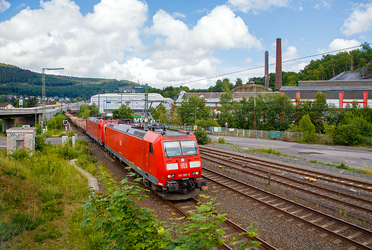 
Die DB Cargo 185 189-8 (TRAXX F140 AC1) und eine kalte 185.2 er (TRAXX F140 AC2) fahren am 02.06.2018 mit einem gem. Güterzug in Richtung Köln, hier zwischen Niederschelden (Nordrhein-Westfalen) und Niederschelderhütte (Rheinland-Pfalz) über die Sieg, die hier Grenzfluss ist.

Hinten rechts im Hintergrund die ehemalige Charlottenhütte (eine ehemalige Eisenhütte).