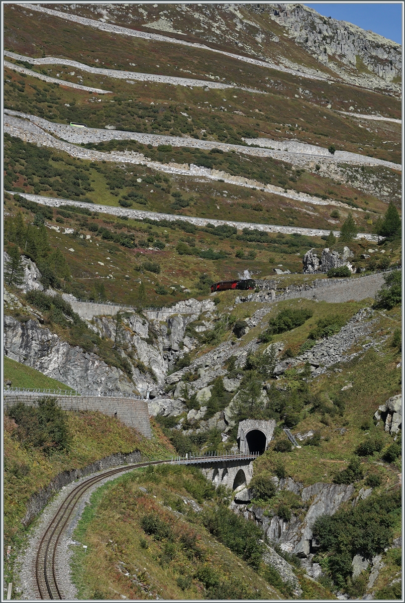 Die DFB (Dampfbahn Furka Bergstrecke) HG 4/4 704 hat mit ihrem Dampfzug 133 Gletsch verlassen und erreicht nun den 548 Meter langen Kehrtunnel  Gletsch . 

30. Sept. 2021