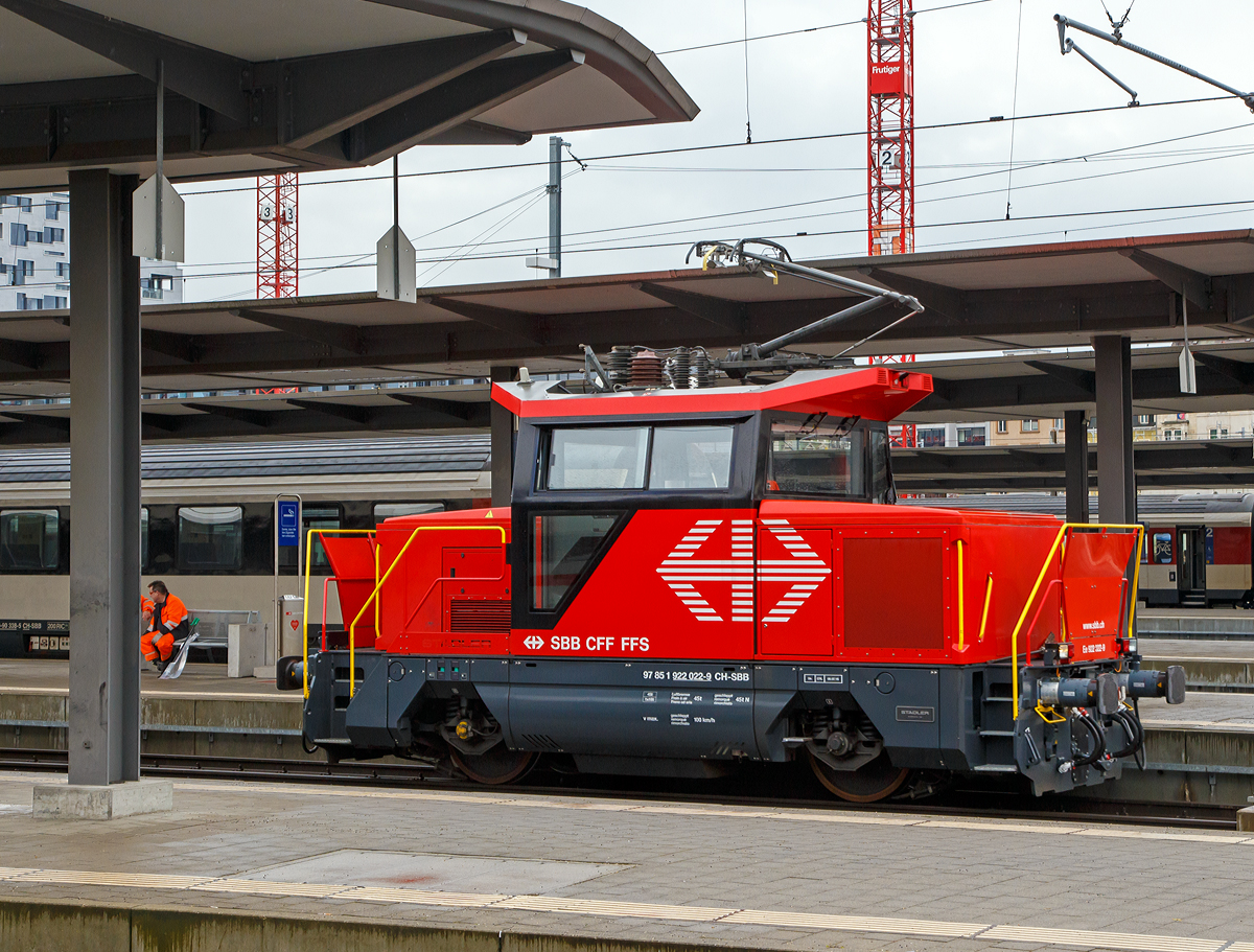 Die Elektrische Zweifrequenz-Rangierlok Ee 922 022-9 (97 85 1 922 022-9 CH-SBB) der SBB f�hrt am 17.02.2017 im Bahnhof Basel SBB.

Die Schweizerische Bundesbahnen (SBB) bestellten im Dezember 2007 eine Serie von 21 Rangierlokomotiven Ee 922 bei Stadler. Die Ee 922 ist eine speziell f�r den Rangierdienst konzipierte elektrische Lokomotive, die auch im Streckenbetrieb eingesetzt werden kann. Sie basiert auf einer von der Stadler Winterthur AG entwickelten Fahrzeugfamilie f�r Traktionsbed�rfnisse im Rangier- und G�terzugf�rderungsdienst.
Die Ee 922 zeichnet sich durch Kompaktheit, gro�e Zugkraft und Leistung sowie optimale Sicht- und Arbeitsbedingungen f�r das Bedienpersonal aus.

Im Dezember 2013 bestellte die SBB vier weitere Ee 922, die 2015 von Stadler geliefert und in Genf und Z�rich stationiert werden sollten. Die Ee 922 022-9 war die erste dieser Serie und wurde 2015 von Stadler gebaut.

Die Ee 922 verf�gt �ber IGBT-Stromrichter und daher �ber zahlreiche Funktionen, welche eher von Regionaltriebz�gen, als von Rangierfahrzeugen bekannt sind. Beispielsweise ist eine R�ckspeisung f�r Bremsenergie in die Fahrleitung oder eine Vielfachsteuerung vorhanden. Auch die H�chstgeschwindigkeit von 100 km/h ist f�r eine Rangierlokomotive recht hoch - und �bertrifft bei weitem die �blichen 45 bis 50 km/h der Ee 3/3. Die hohe  H�chstgeschwindigkeit bef�higt die Ee 922, zusammen mit der Vielfachsteuerung, auch f�r kleinere Streckeneins�tze wie beispielsweise �berf�hrungsfahrten. Die Lokomotive wurde vom Hersteller (Stadler)  f�r eine H�chstgeschwindigkeit von 120 km/h ausgelegt, um die M�glichkeit f�r einen Zweitauftrag offen zu halten. Konstruktiv ist die Lokomotive f�r ein Gesamtgewicht von 45 Tonnen ausgelegt. Ihr �bliches Gewicht betr�gt 44 Tonnen, kann aber auf 40 Tonnen herabgesetzt werden. Die Gewichtsdifferenz wird von zwei Ballastk�rper mit je zwei Tonnen Gewicht erzeugt. Sie befinden sich seitlich an der Lokomotive und k�nnen mit einem Gabelstapler entfernt werden. Dies ist notwendig, da noch nicht alle Abstellgleise f�r 22,5 Tonnen Achslast (Streckenklasse D), sondern oft nur f�r 20 Tonnen Achslast (Streckenklasse  C) zugelassen sind.

Die �u�eren Konturen entsprechen den Lichtraumprofilvorgaben nach UIC 505-1, und im Unterbereich den Vorgaben nach AB-EBV U3. Damit erf�llt die Lokomotive mit ihrer Bodenfreiheit vom 100 mm im Radbereich die Lichtraumprofil-Vorgaben f�r alle europ�ischen Hauptstrecken. Die Einstiegt�ren ins F�hrerhaus befinden sich auf den Stirnseiten, um einen direkten Zugang zu den Rangiererb�hnen zu erm�glichen, daf�r sind die Vorbauten jeweils seitlich versetzt. Das klimatisierte F�hrerhaus ist f�r eine optimale Sicht gro�z�gig verglast, die vorspringenden Vord�cher sch�tzen vor Sonneneinstrahlung sowie vor der Ber�hrung spannungsf�hrender Teile der Dachausr�stung.

Der elektrische Teil entspricht technisch weitgehend dem Stadler Flirt und dem neueren GTW. Er ist aber nicht baugleich, sondern musste aus Platzgr�nden an ein anderes Geh�use angepasst werden. 

Die Ee 922 besitzt ein Schwingungstilgungssystem. Gerade ein zweiachsiges Eisenbahnfahrzeug mit geringem Achsstand neigt zu Schlingerbewegungen, da so gut wie keine D�mpfungen eingebaut werden k�nnen. 


Technische Daten:
Gebaute St�ckzahl: 25
Spurweite: 1.435 mm (Normalspur)
Achsanordnung: Bo
Speisespannung: 15kV / 16.7Hz und 25kV / 50Hz
Anzahl Fahrmotoren: 2 
L�nge �ber Puffer: 8.800 mm
Fahrzeugbreite: 3.100 mm
Fahrzeugh�he: 4.306 mm
Dienstgewicht: 40 t / 44 t (umr�stbar, je nach Streckenklasse)
Achsabstand: 4.000 mm
Max Leistung am Rad: 750 kW (1.020 PS)
Dauerleistung:  600 kW
Anfahrzugkraft: 120 kN
H�chstgeschwindigkeit: 40 km/h im Rangiergang; 100 km/h (Auslegung 120 km/h)
Treibraddurchmesser:  1.100 mm (neu)
Stromsystem:  15 kV 16,7 Hz und 25 kV 50 Hz
Lokbremse:  Druckluftbremse, Federspeicher, elektrische Bremse
Zugbremse:  automatische Druckluftbremse
Zugheizung:  ZZS 1000 V 800 A
