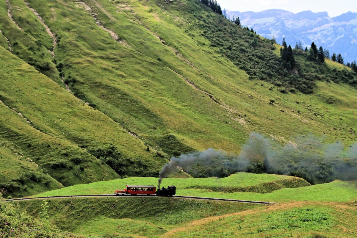 Die kleine Lok 5 mit ihrem Salonwagen 27 und dem Vorstellwagen M3 im Aufstieg oberhalb Planalp. 3.August 2023 